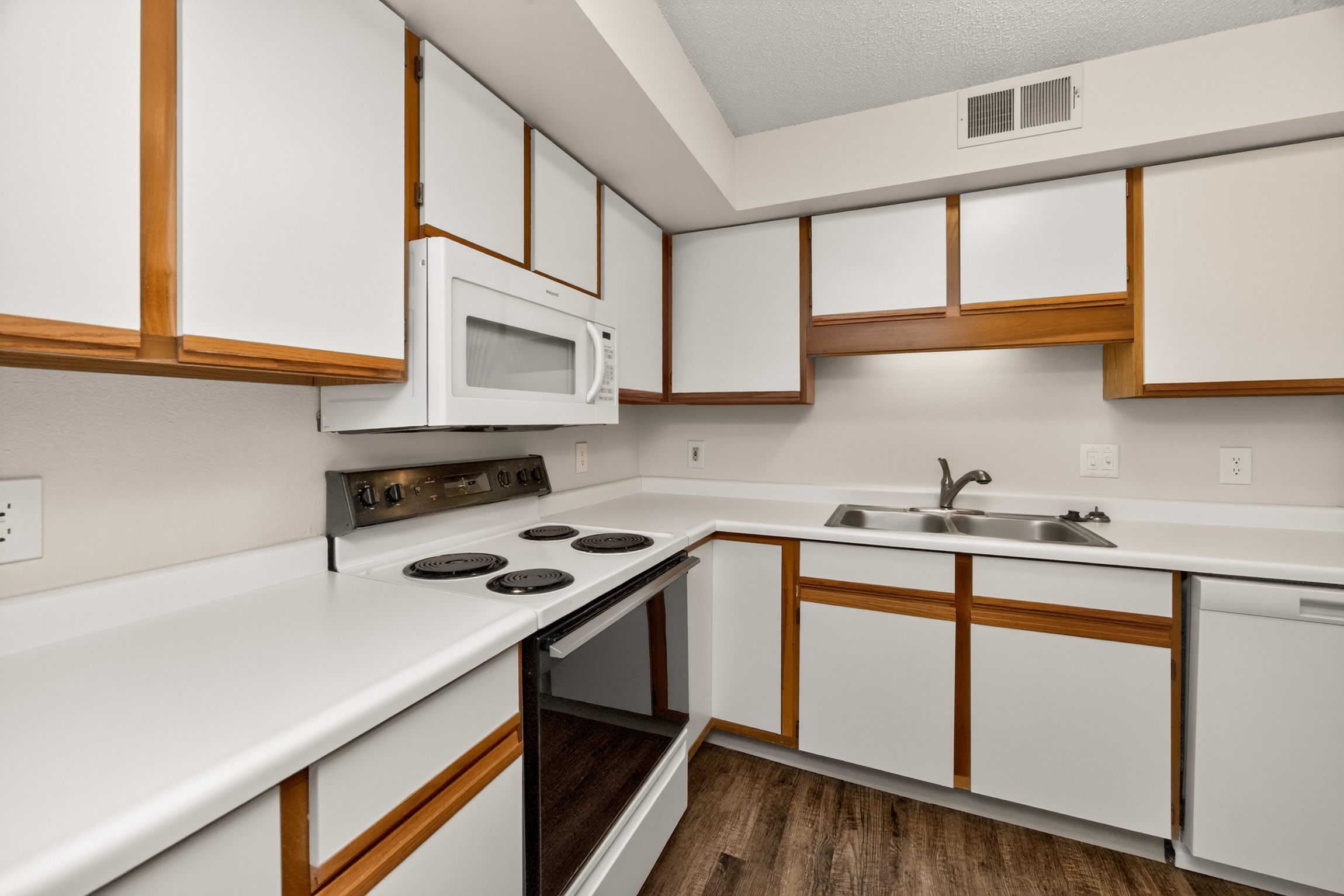 A kitchen with white cabinets and a black dishwasher.