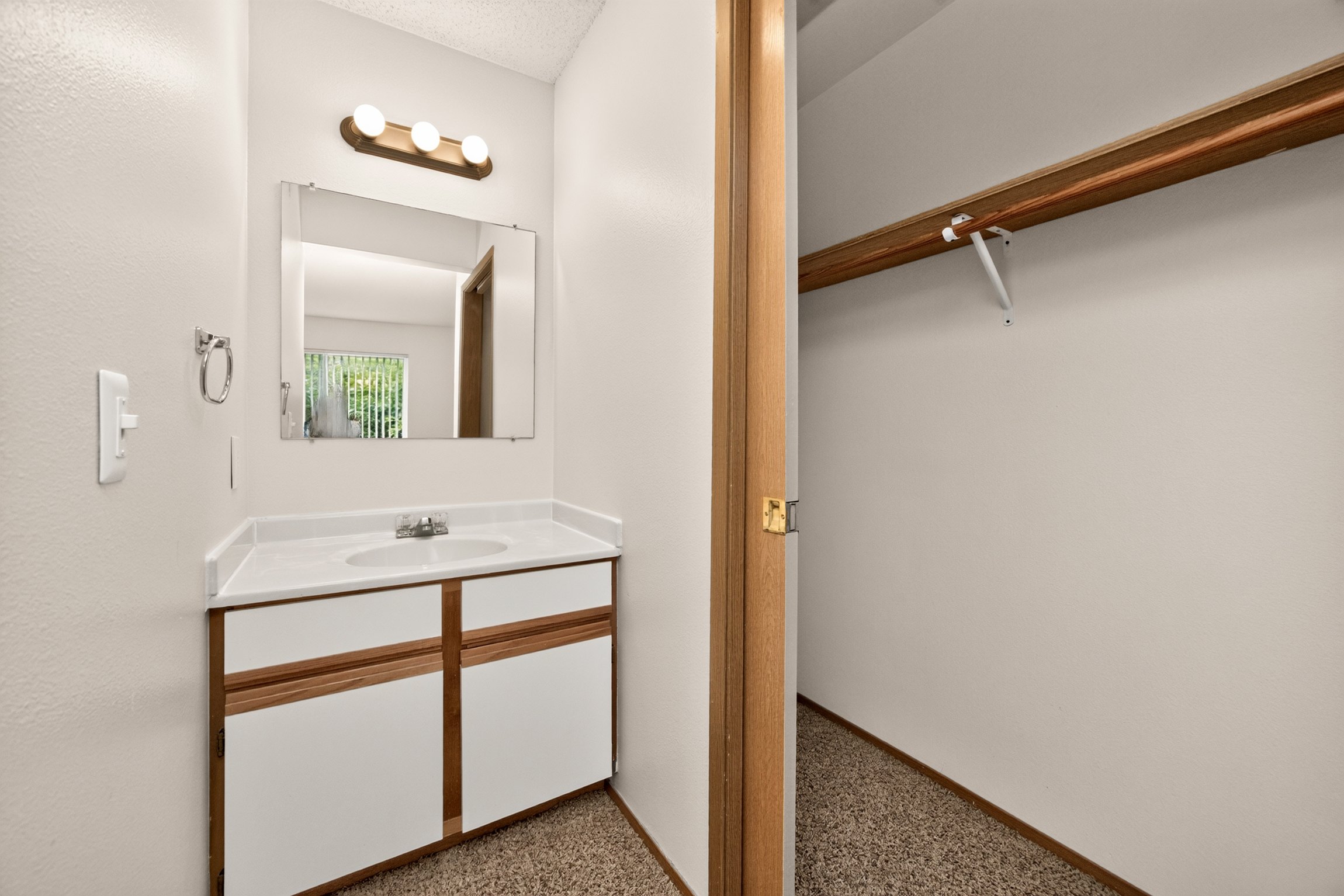 A bathroom with a sink, mirror, and cabinet.