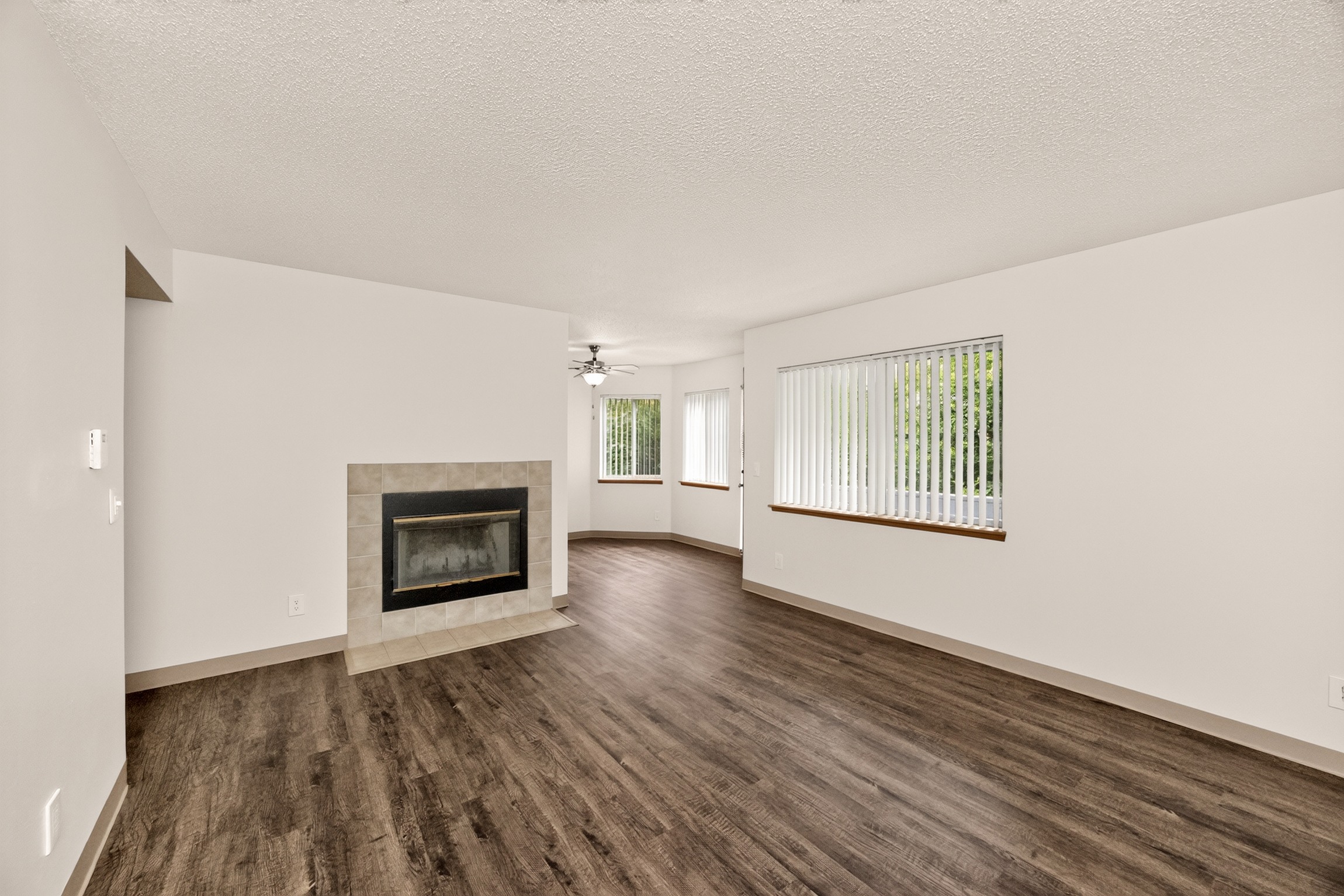 A living room with a fireplace and wood flooring.