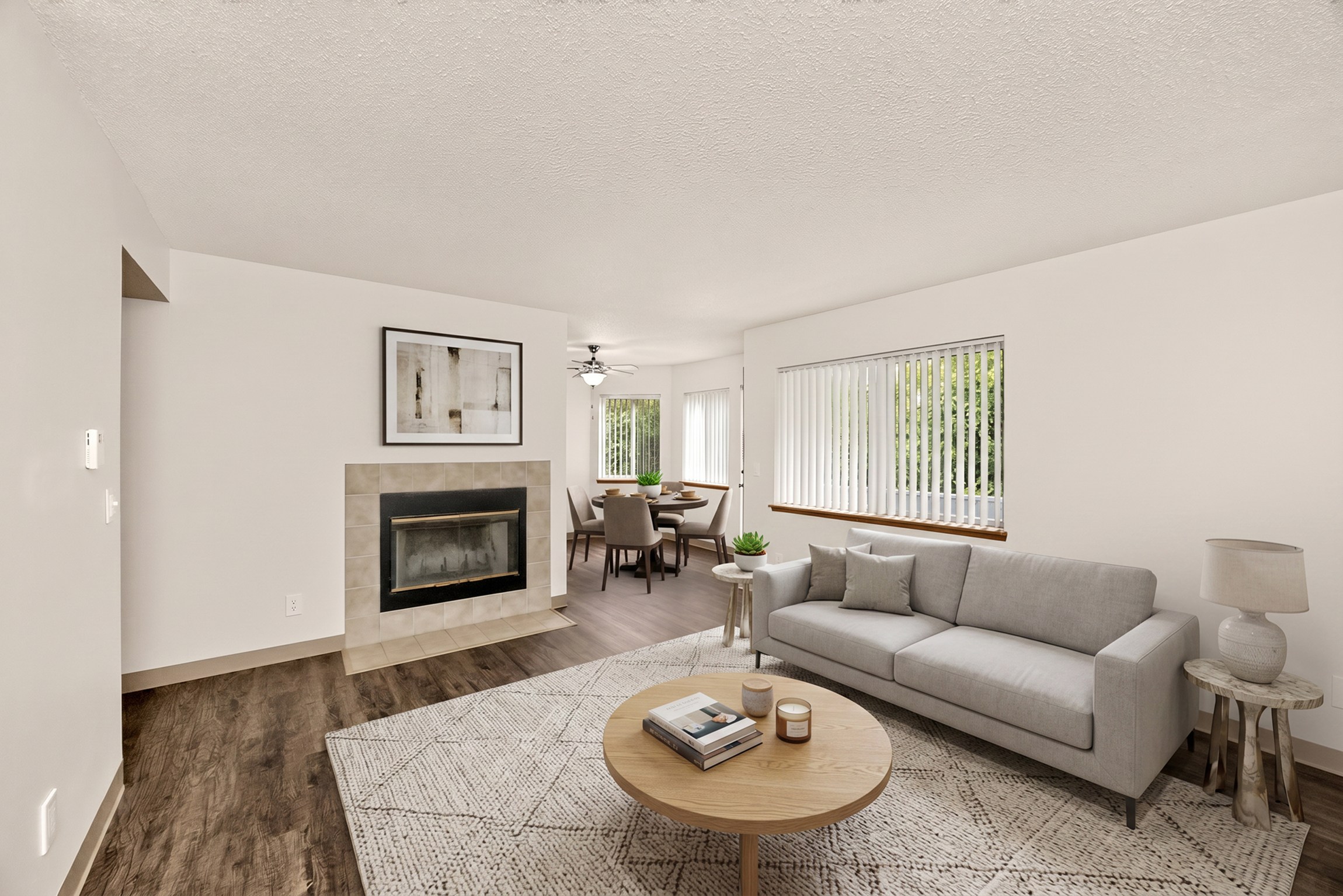 A living room with a grey couch, a fireplace, and a coffee table.