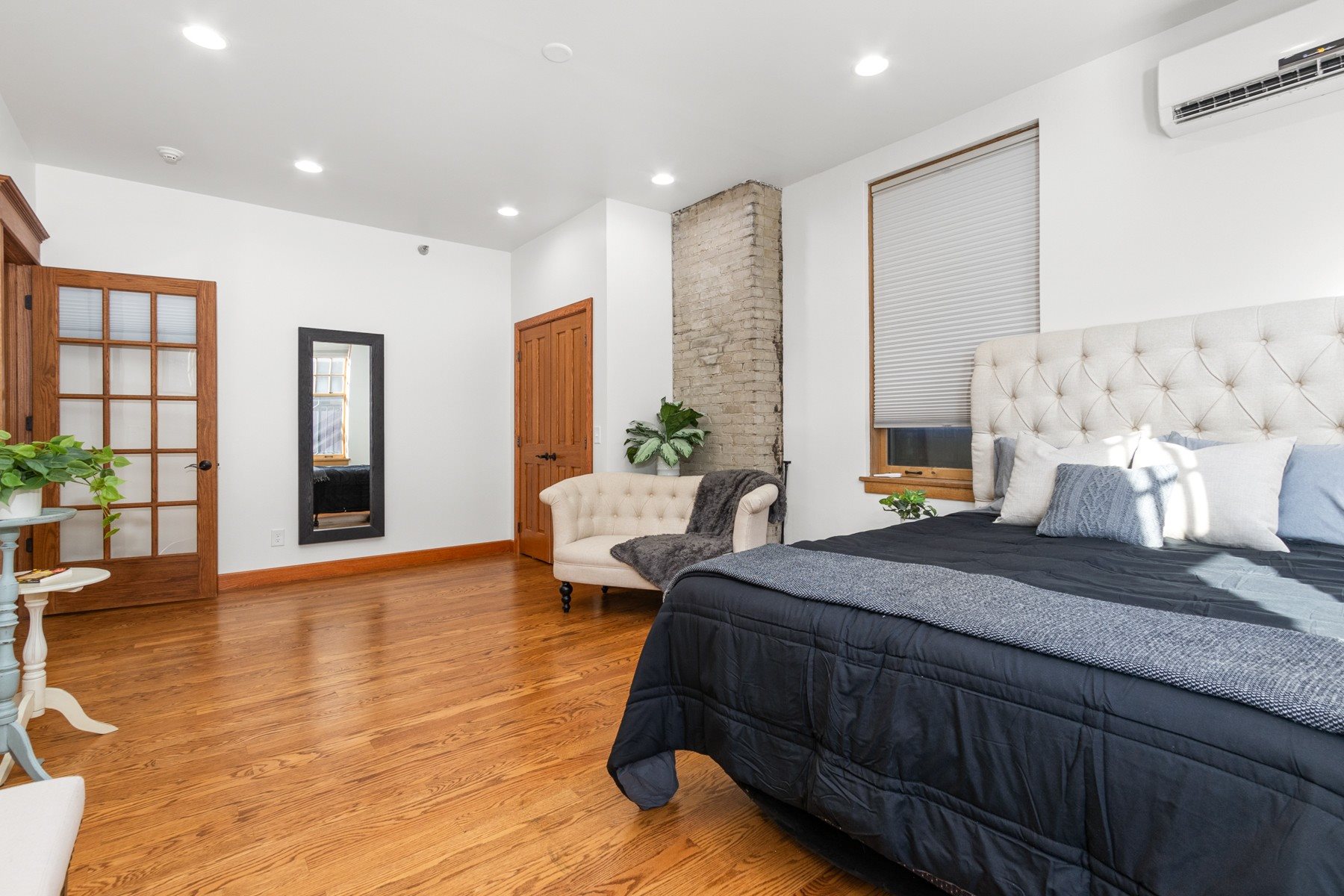 A bedroom with a large bed and a white headboard.