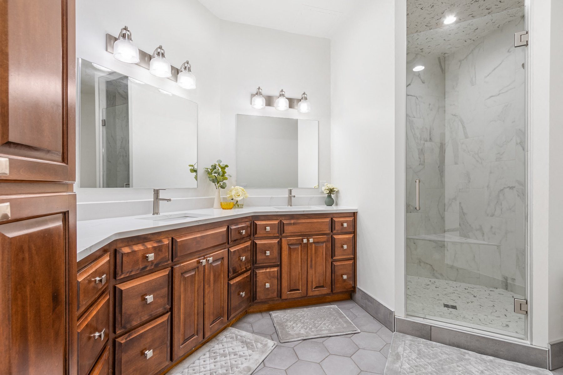 A bathroom with a marble floor and a walk-in shower.