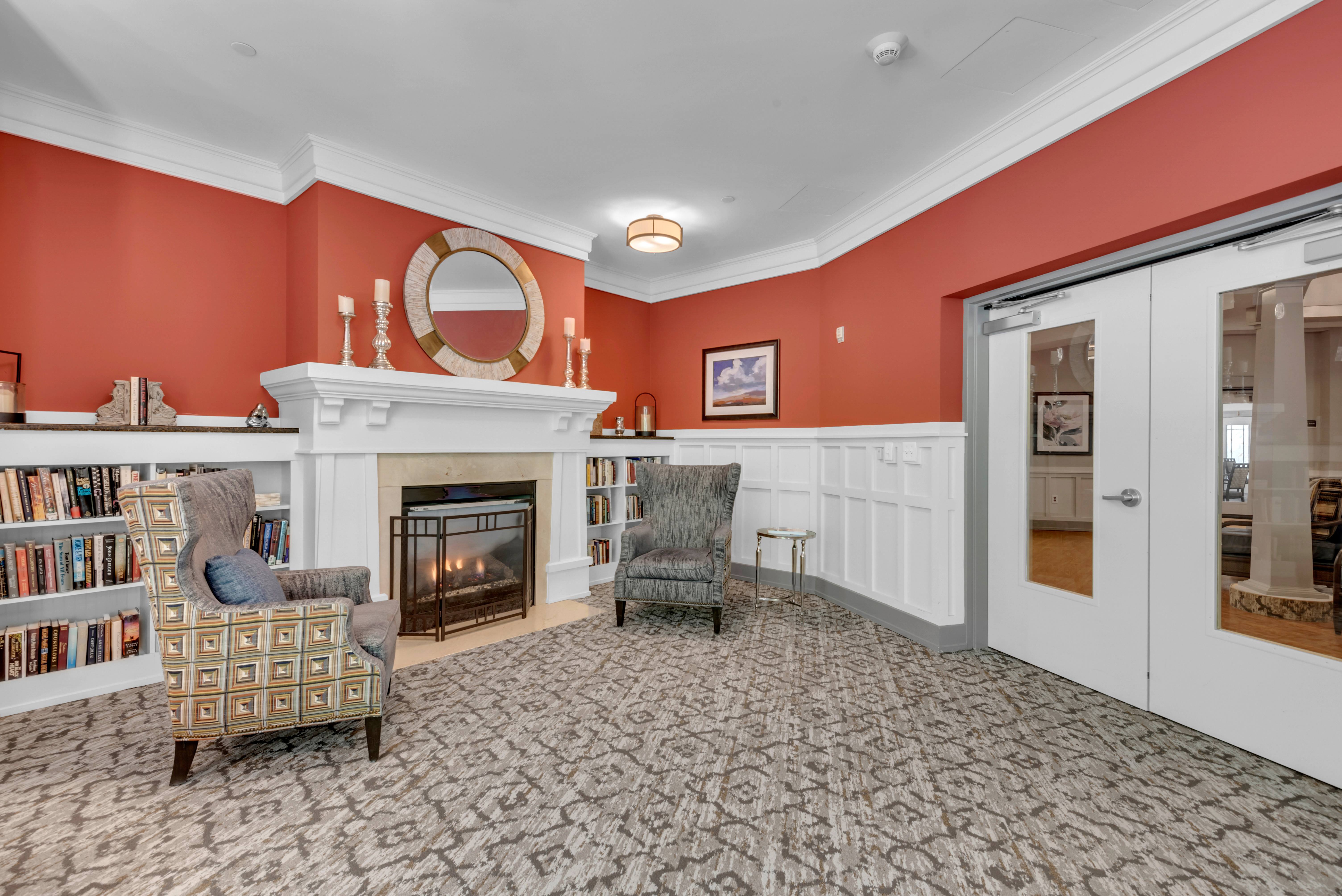 A living room with a fireplace and a chair.at Spring Arbor of Severna Park, Severna Park, 21146