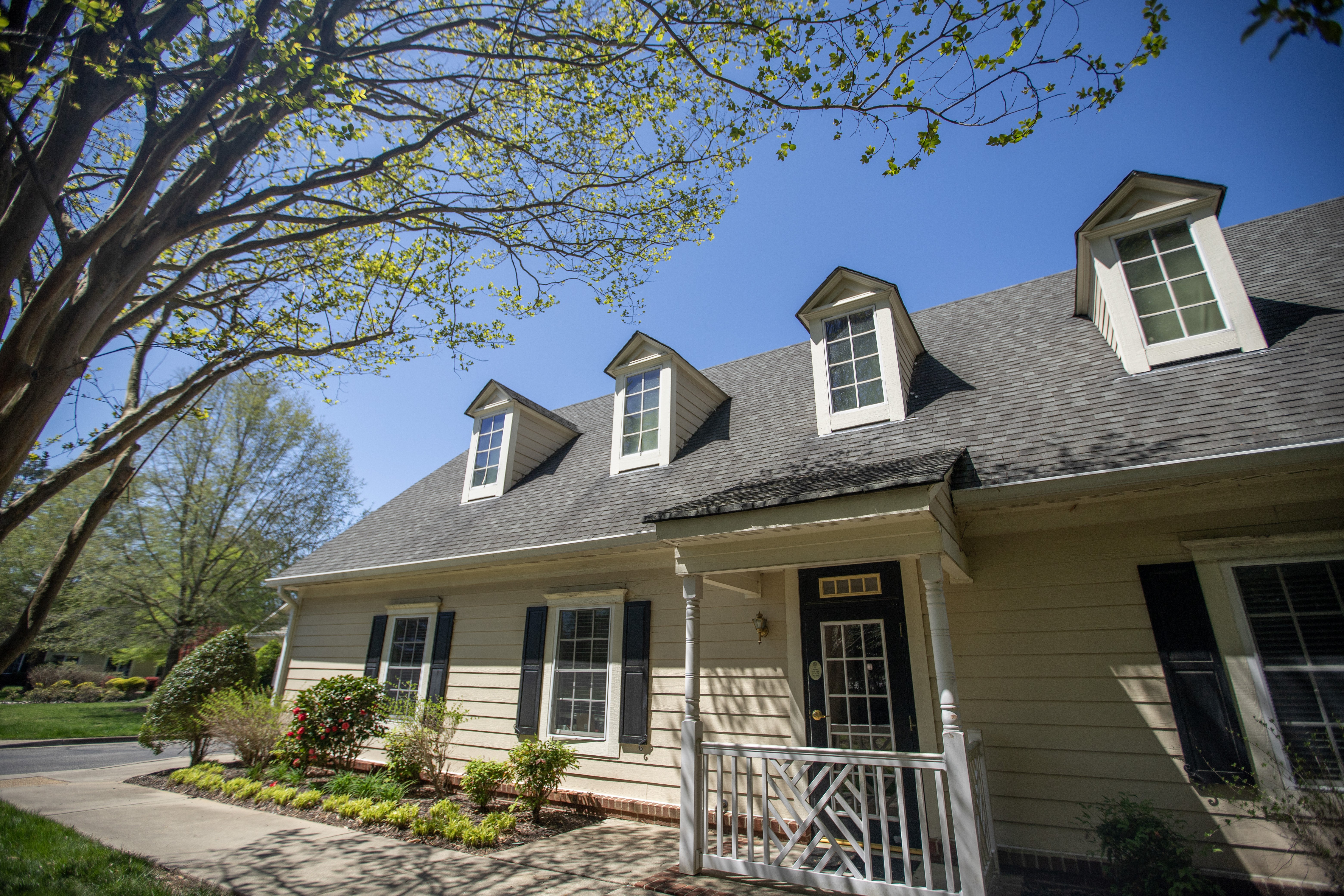 A house with a white porch and a black door at Spring Arbor of Williamsburg, Williamsburg, VA, 23185