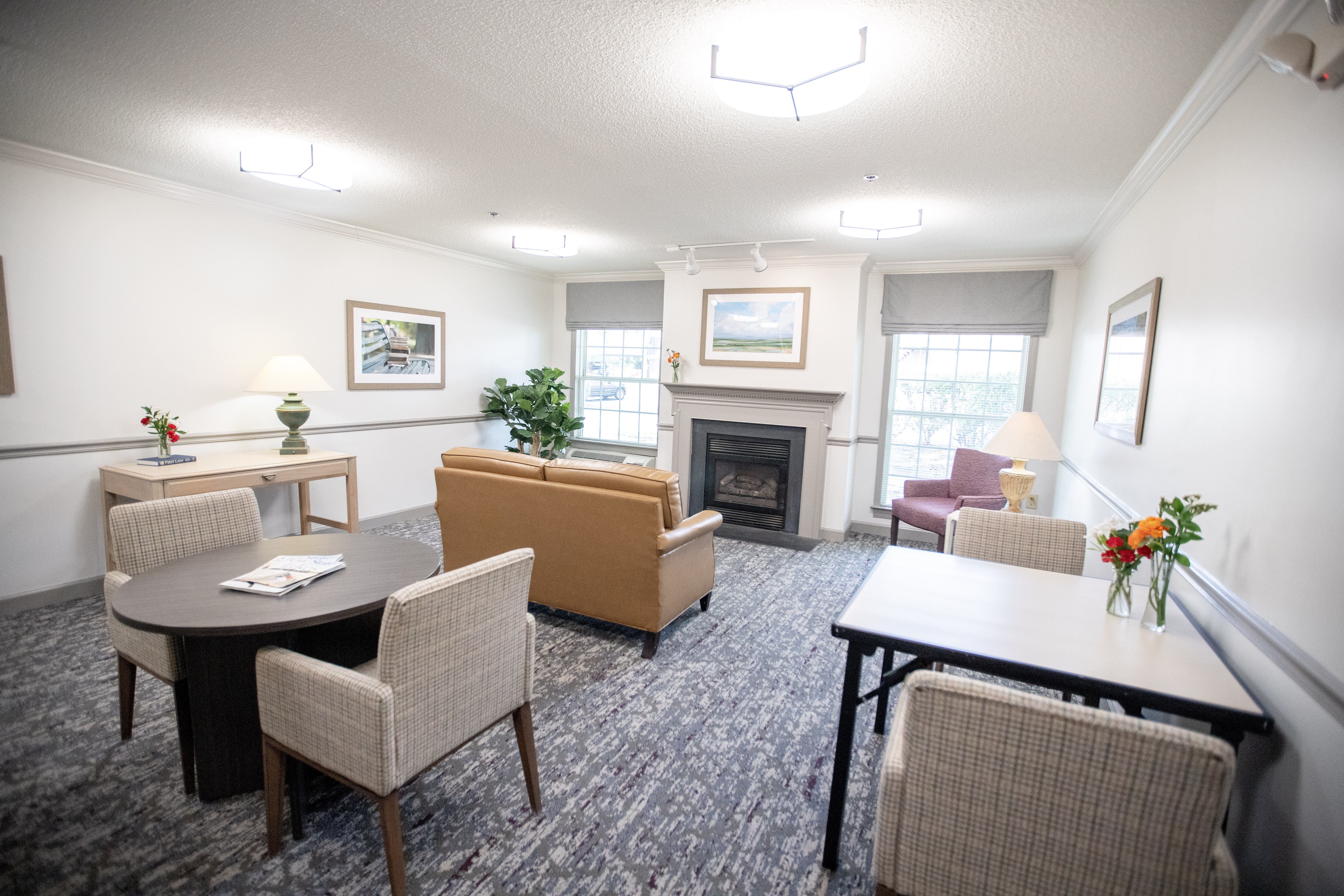 A living room with a fireplace and a dining table.at Spring Arbor of Wilson, North Carolina, 27893-2873