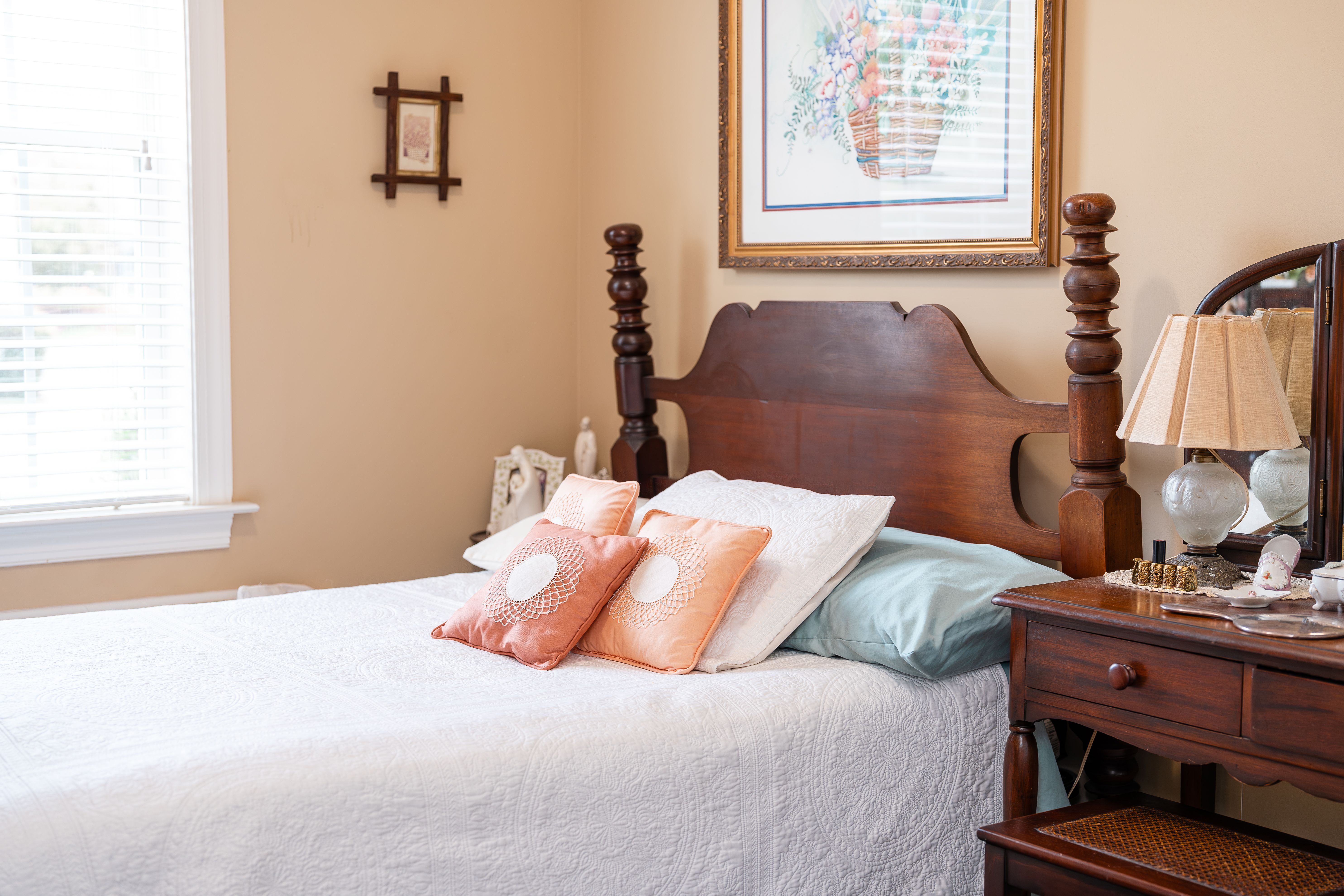 A bedroom with a bed, nightstand, and a painting on the wall at Spring Arbor of Cary in Cary, NC