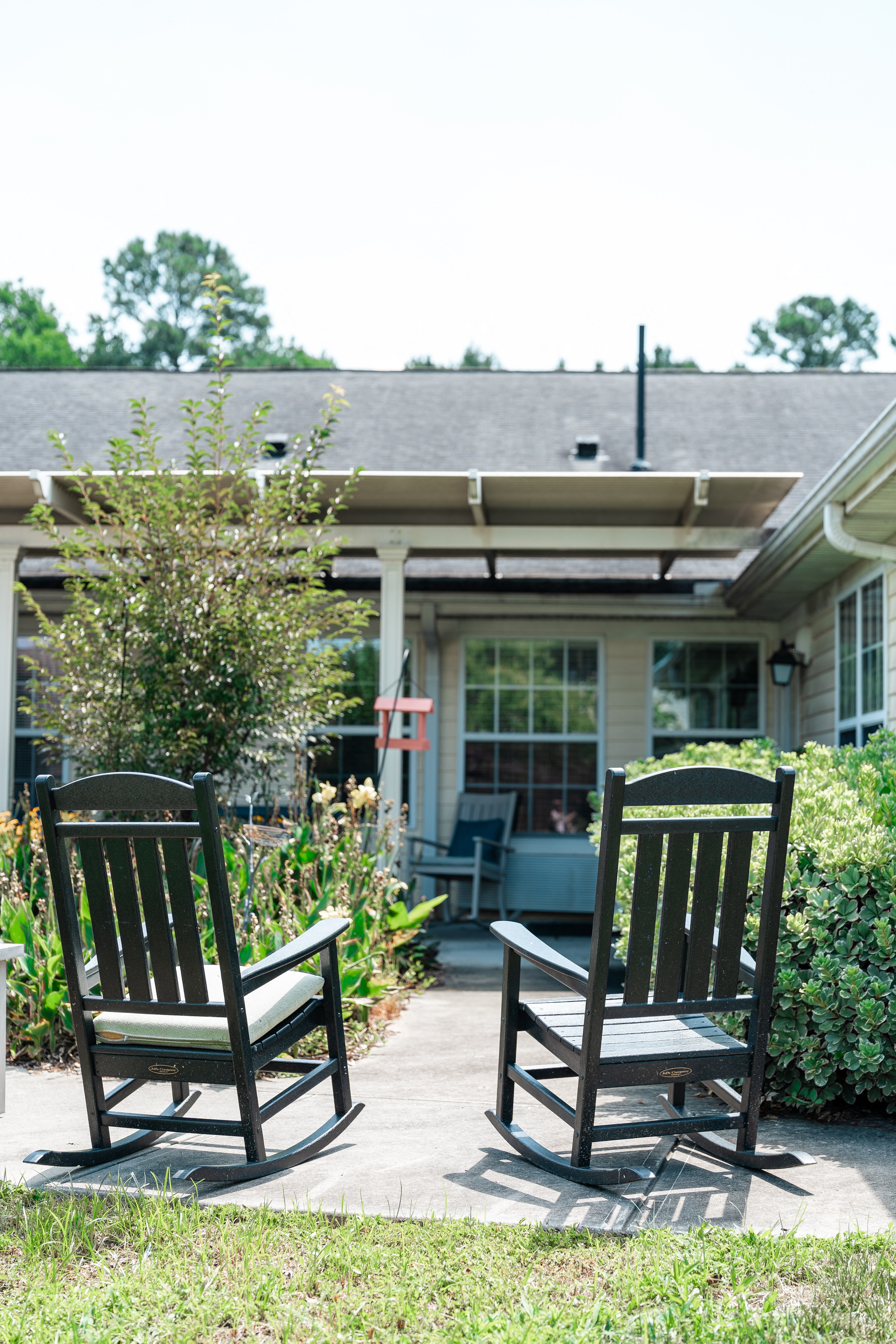 Two rocking chairs on a patio in front of a house at Spring Arbor of Albemarle, Albemarle