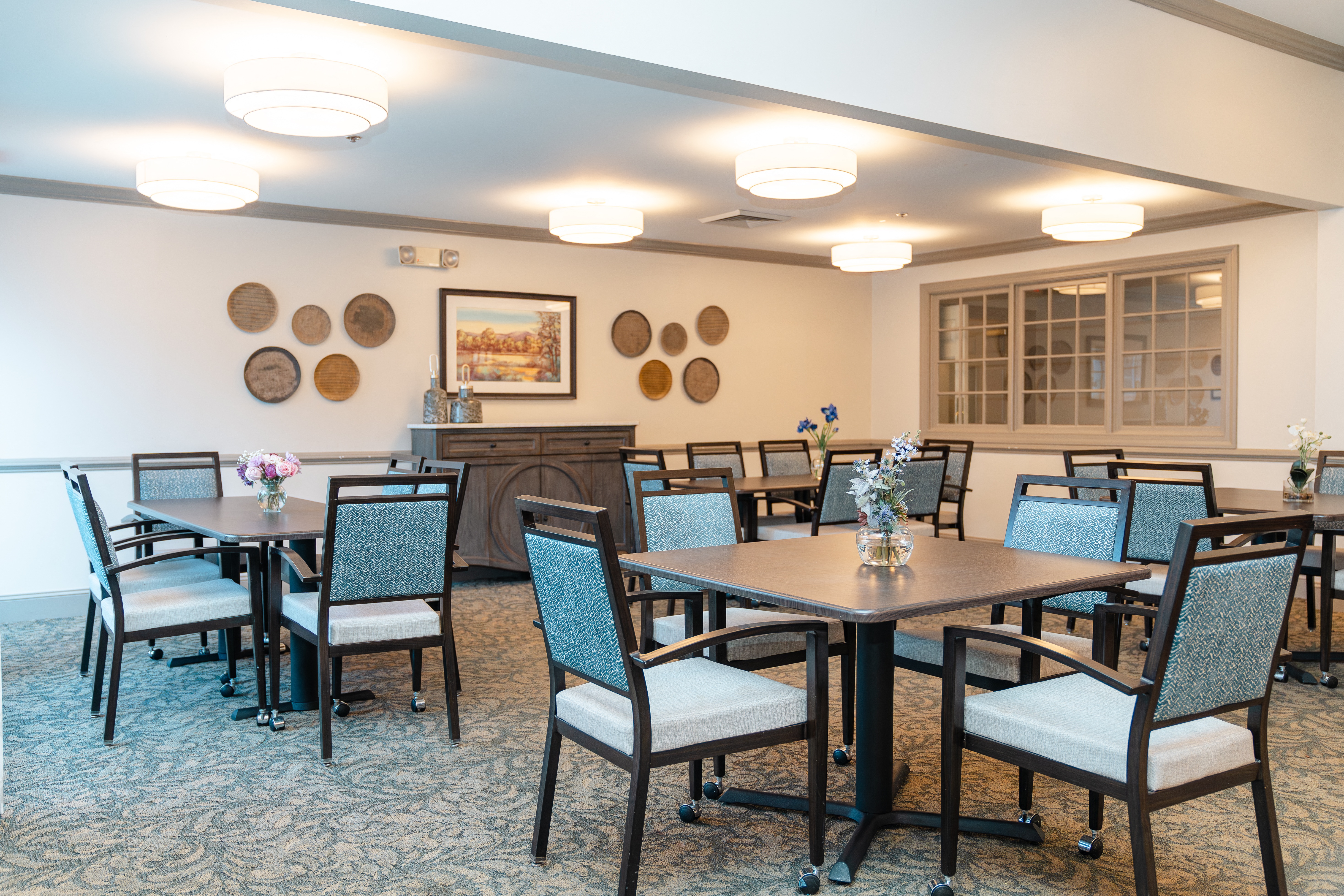 Dining room with tables and chairs and a fireplace at Spring Arbor of Apex