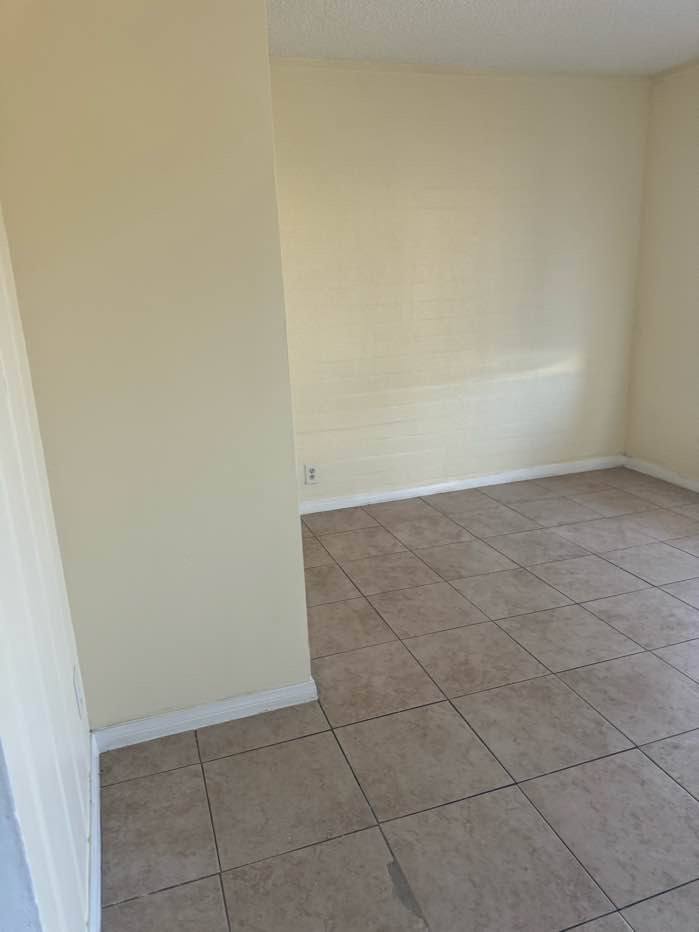 A room with beige walls and tile flooring.