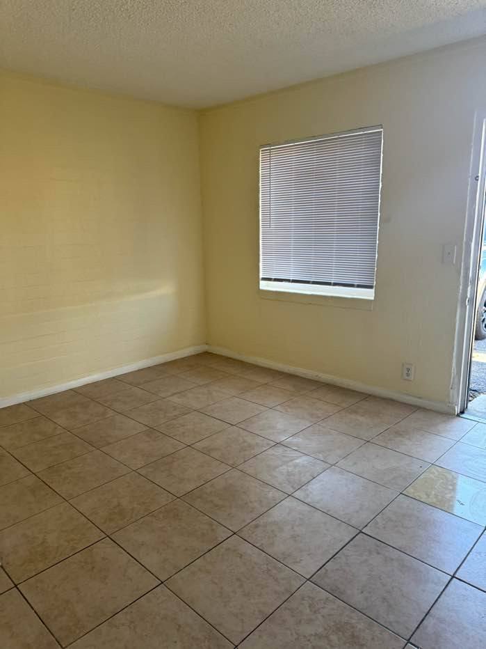 A room with a window and tiled floor.