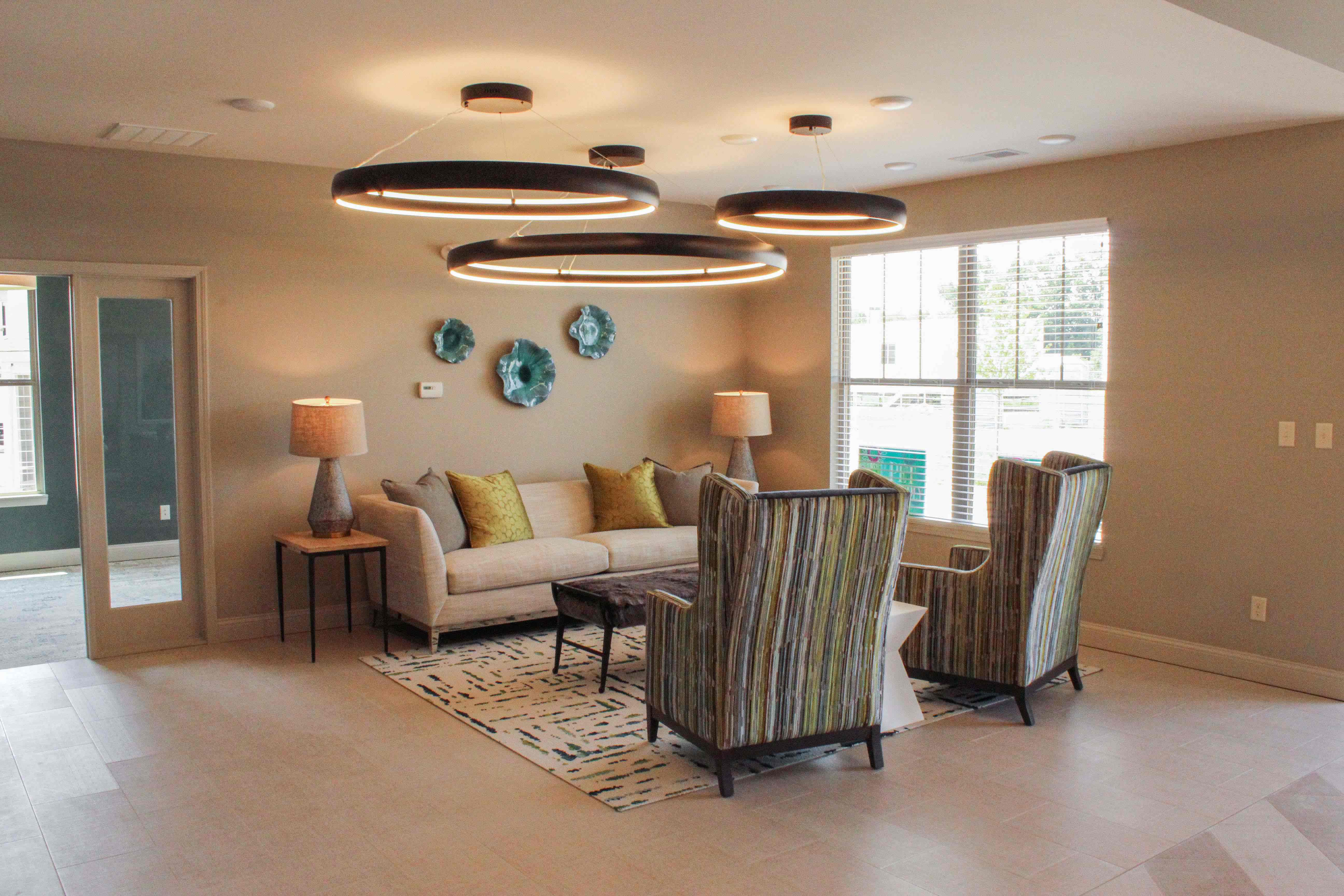 Living-Room shot of a Unit at Villas of Jeffersonville. Ceiling lights and a sofa and two chairs.