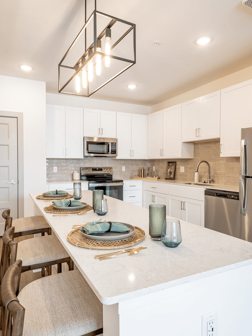 Inside of a kitchen with a black stove top and microwave above it