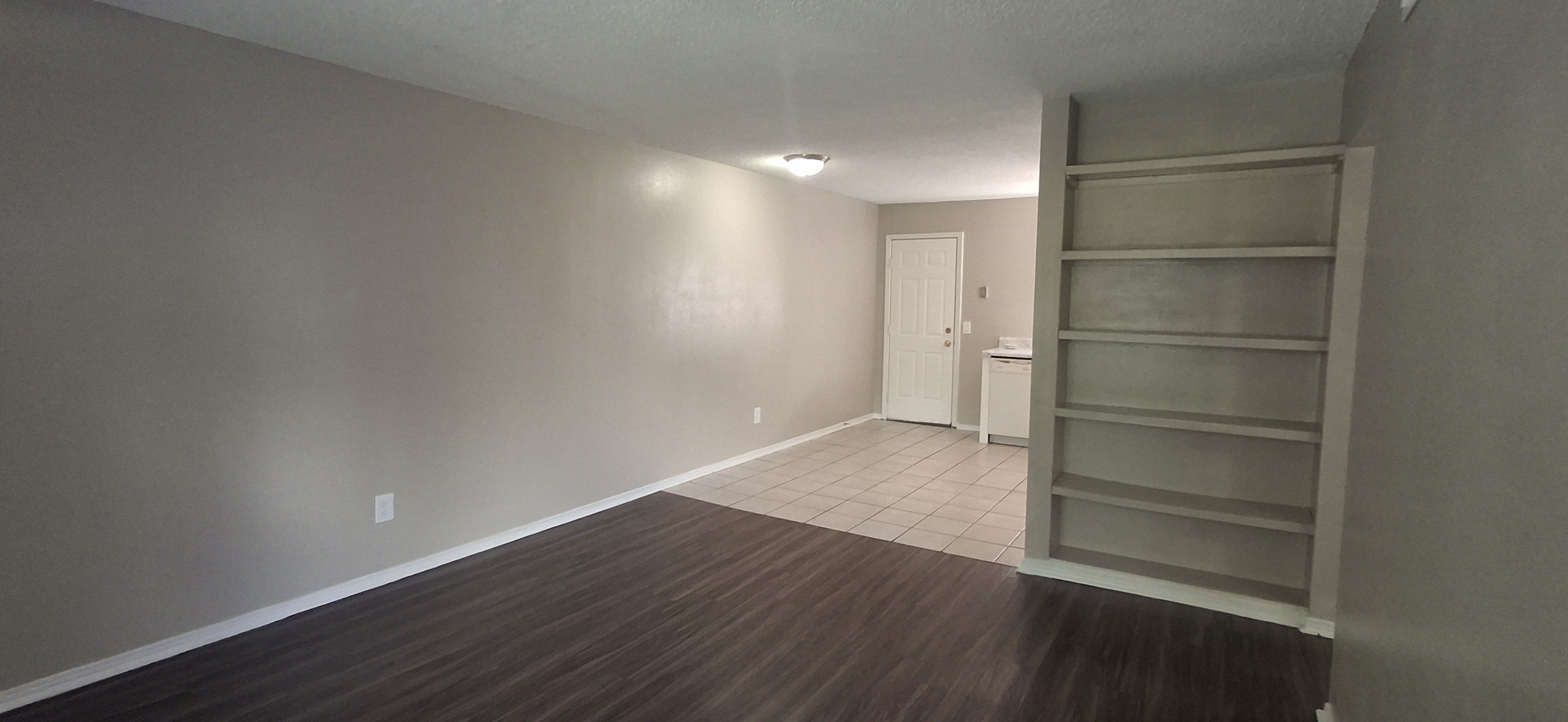 A room with a wooden floor and a white door.
