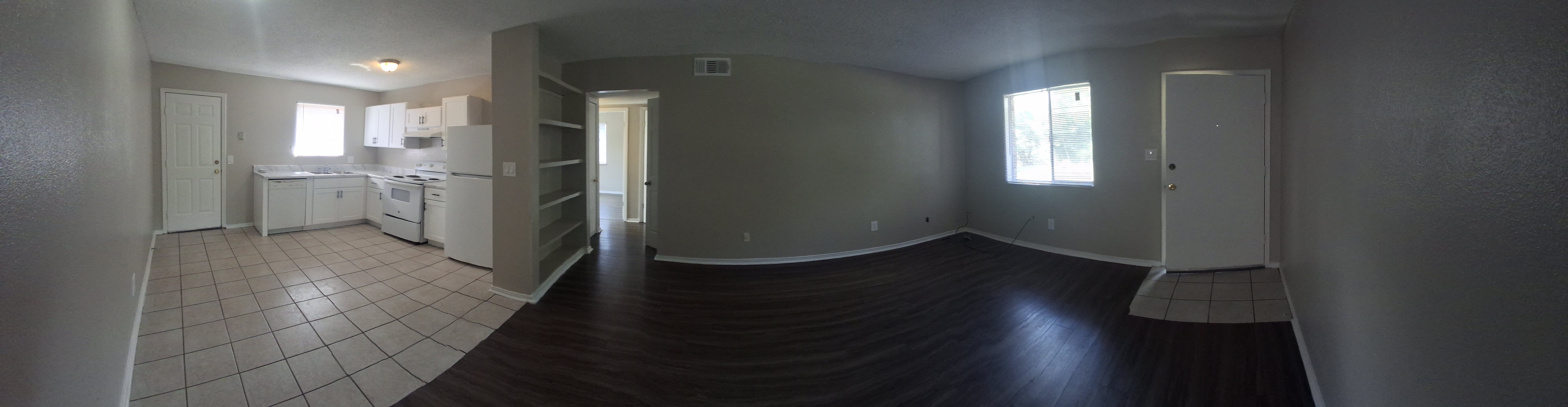 A kitchen with white appliances and a dining table.
