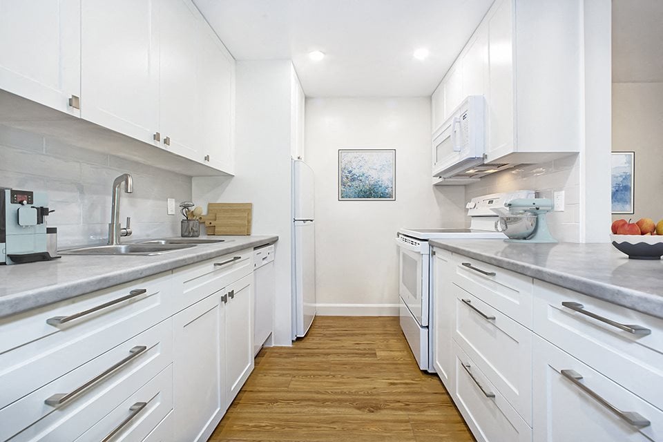 Park Towers Apartments image of kitchen showing white cabinetry and four appliances of a renovated 1 bedroom in London, ON