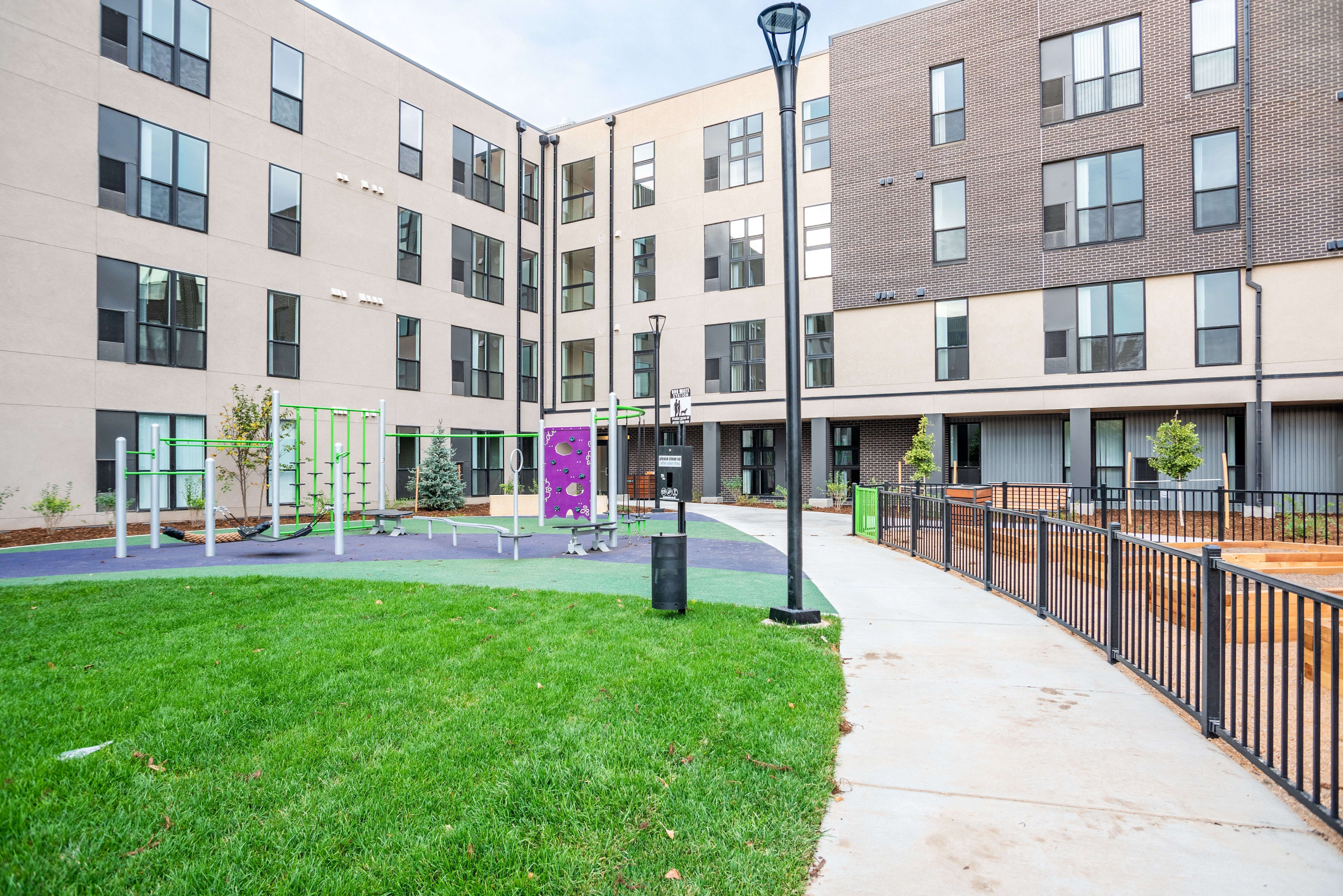 Outdoor recreational space with open space, playground, and raised garden beds