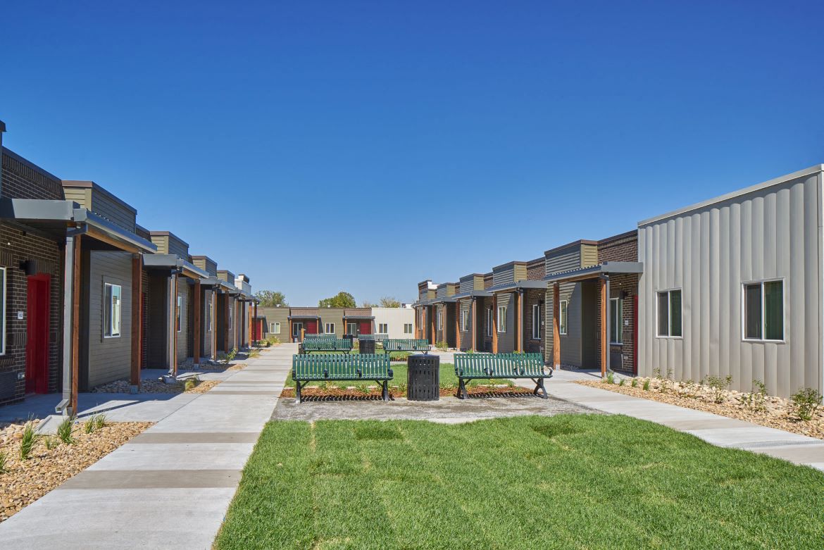 Exterior view of VWC3 showing courtyard surrounded by units made up of green grass and benches