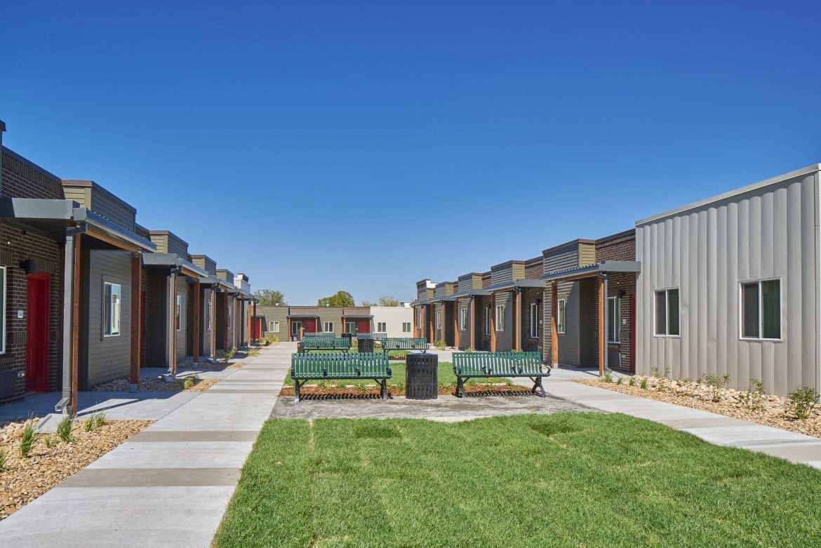 Exterior view of VWC3 units with courtyard in the middle made up of green grass and benches