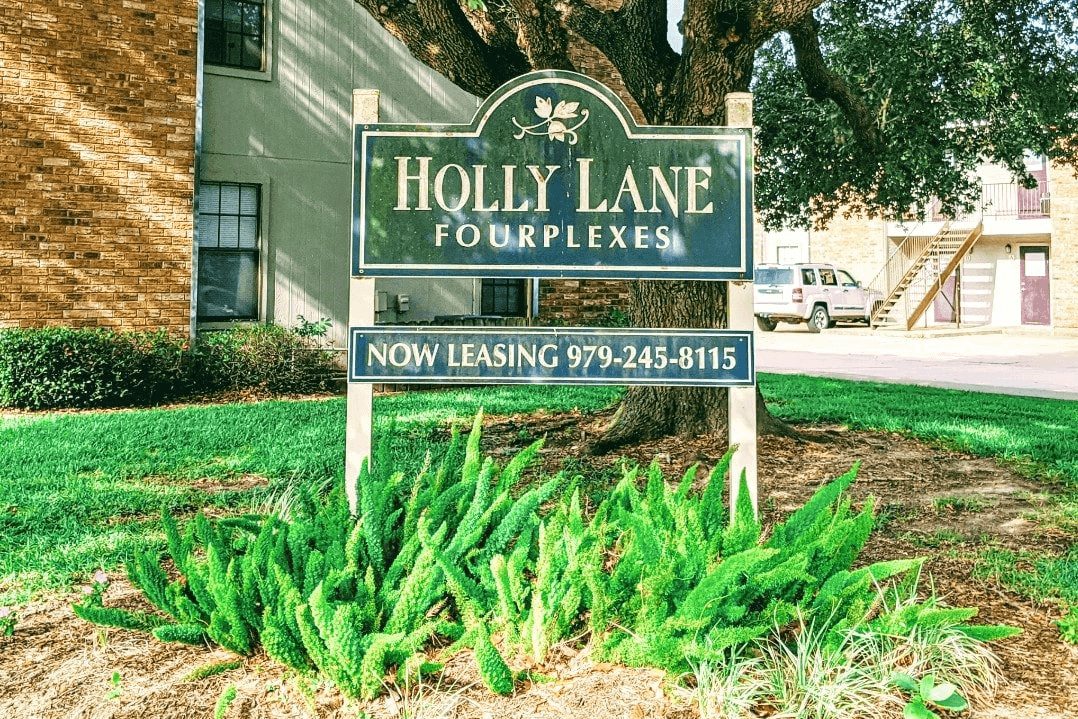 A sign for the Holly Lane Fourplexes building