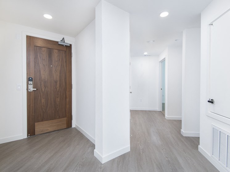 Spacious Foyer With Natural Wood Door At The Club At Enclave Apartments In Chula Vista, CA