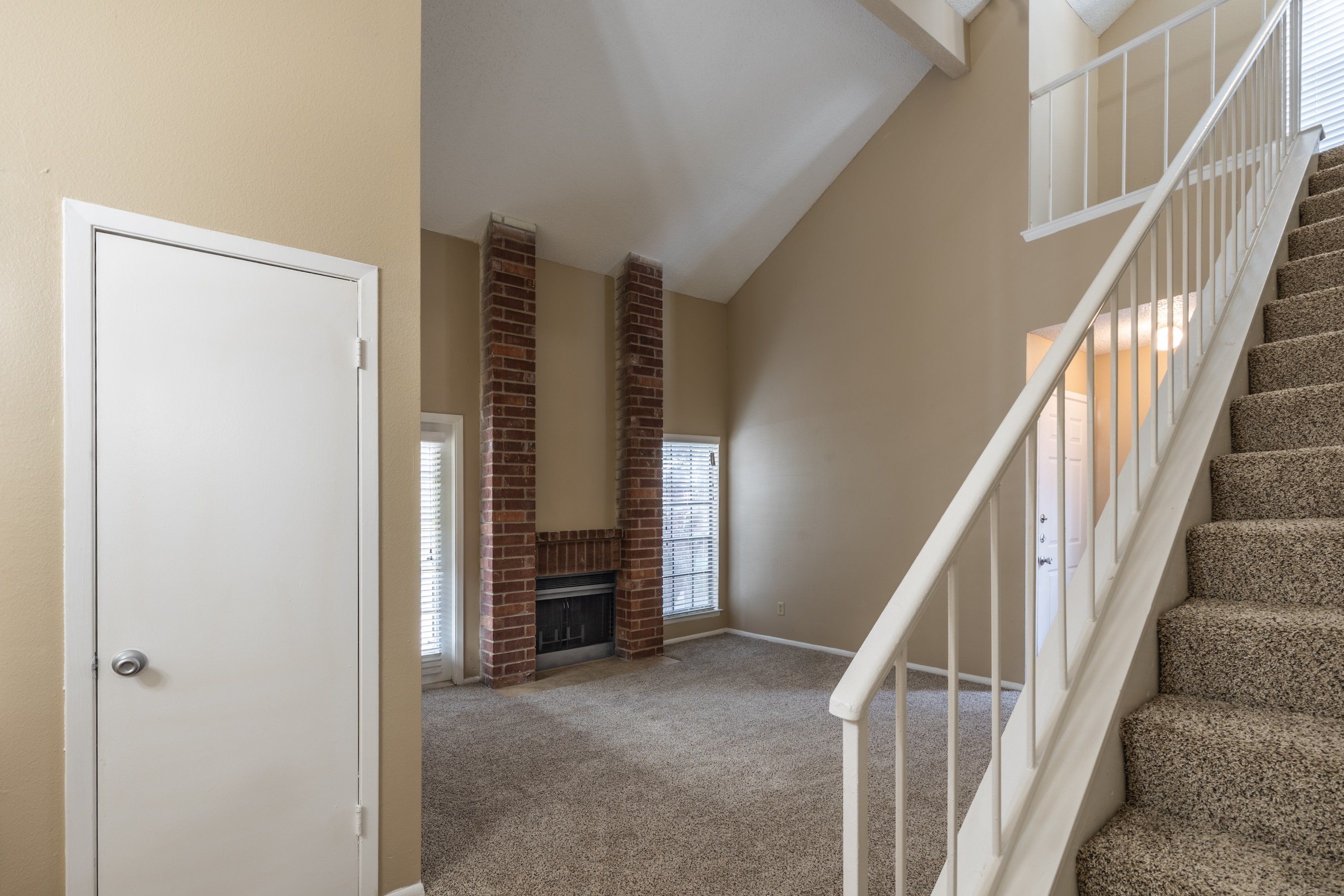 A room with a staircase and a fireplace.