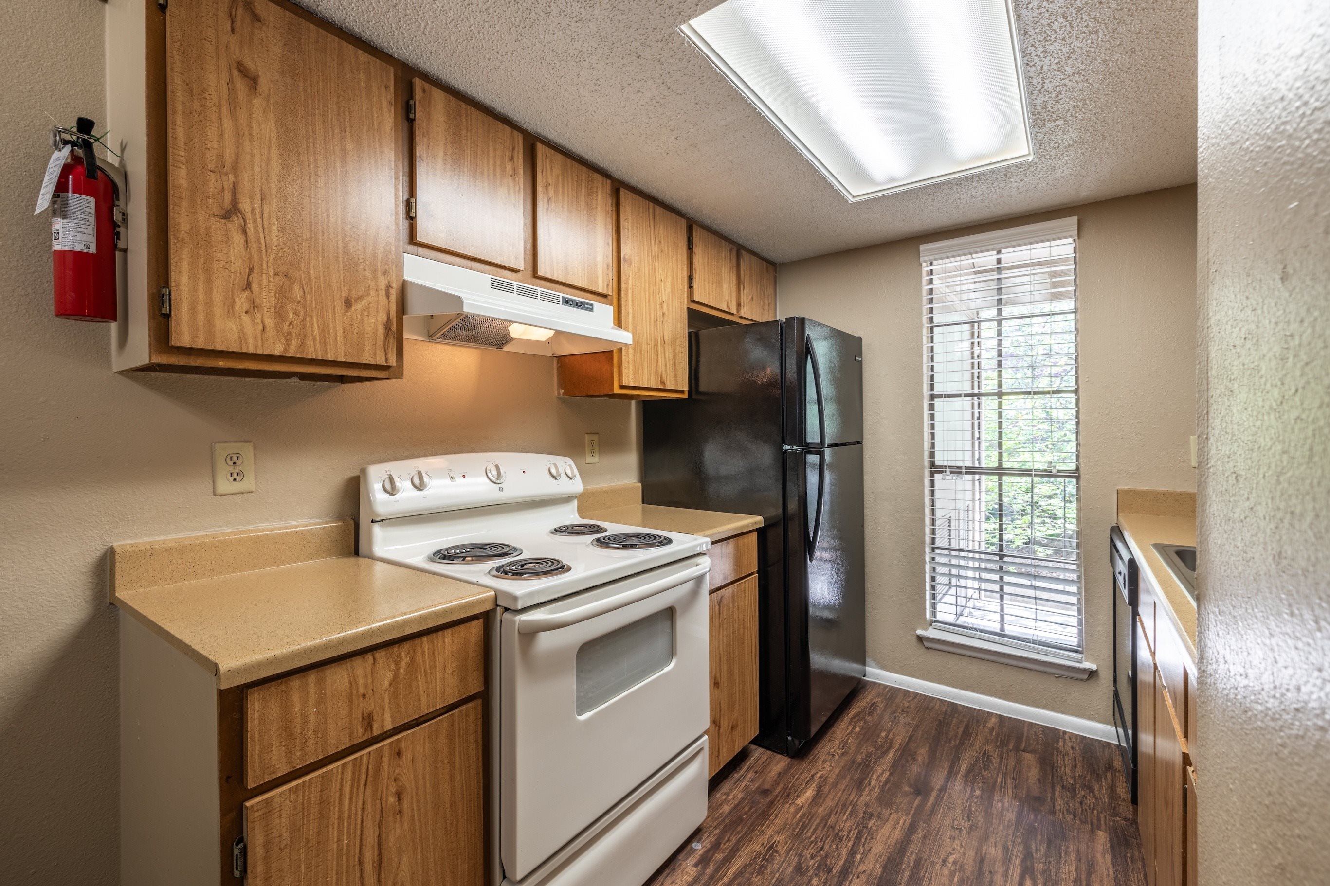 A kitchen with a white stove and black refrigerator.