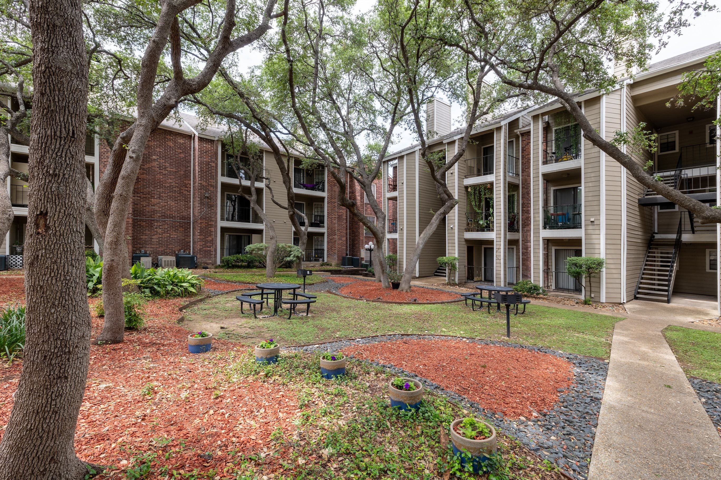 A courtyard with a picnic table surrounded by apartment buildings.