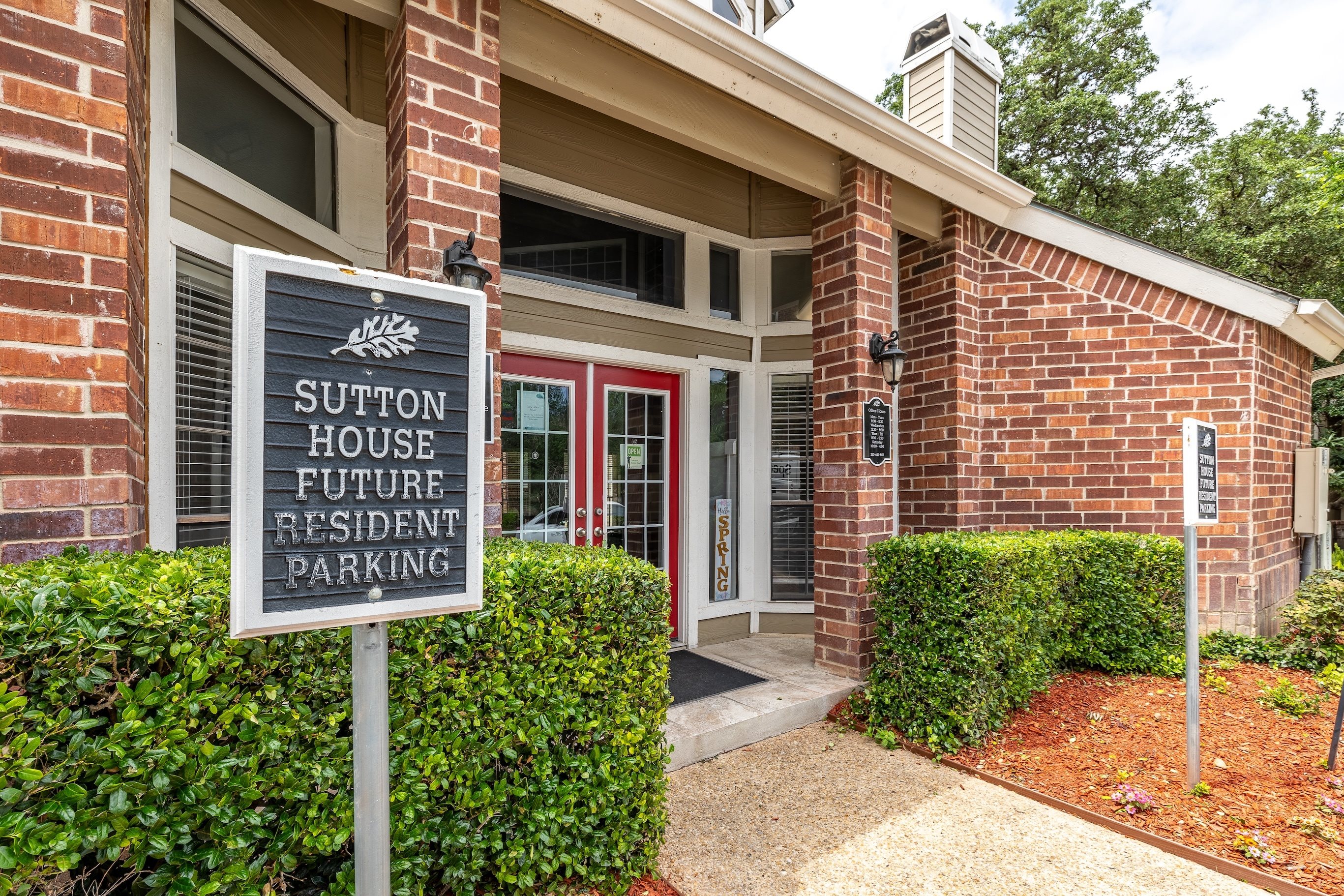 A sign in front of a building that says Sutton House Future Resident Parking.