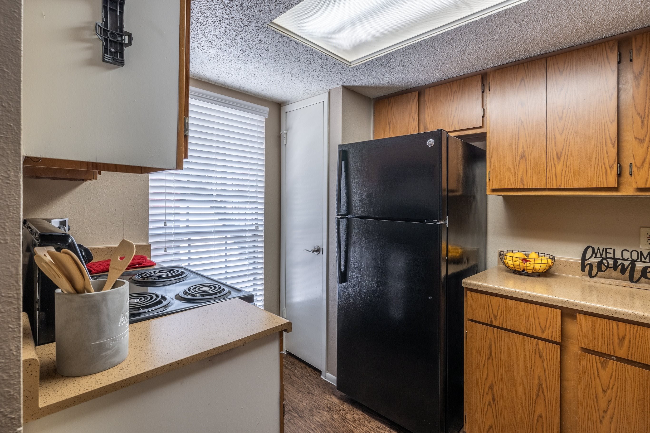 A black refrigerator sits in a kitchen next to a counter.