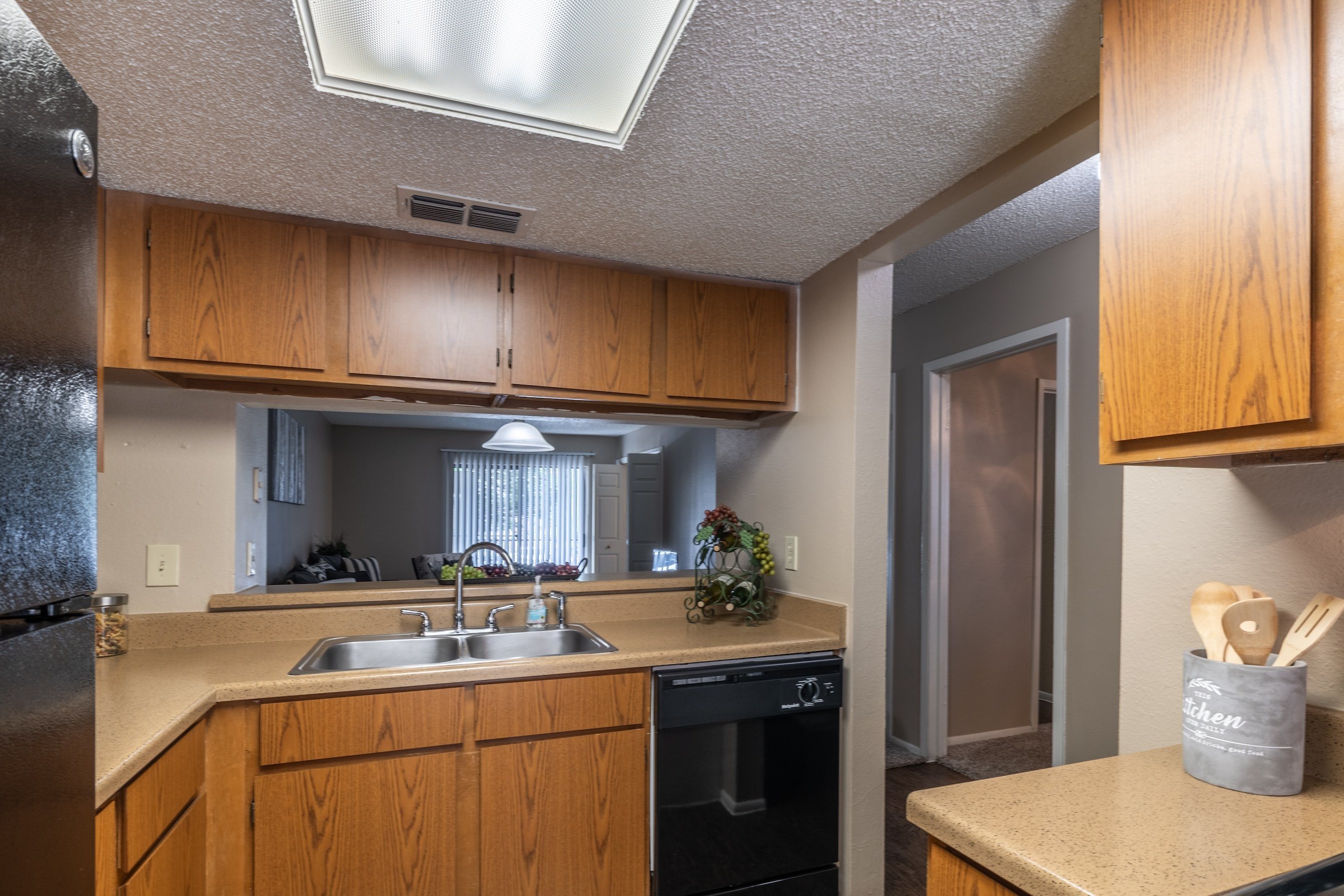 A kitchen with wooden cabinets and a stainless steel refrigerator.