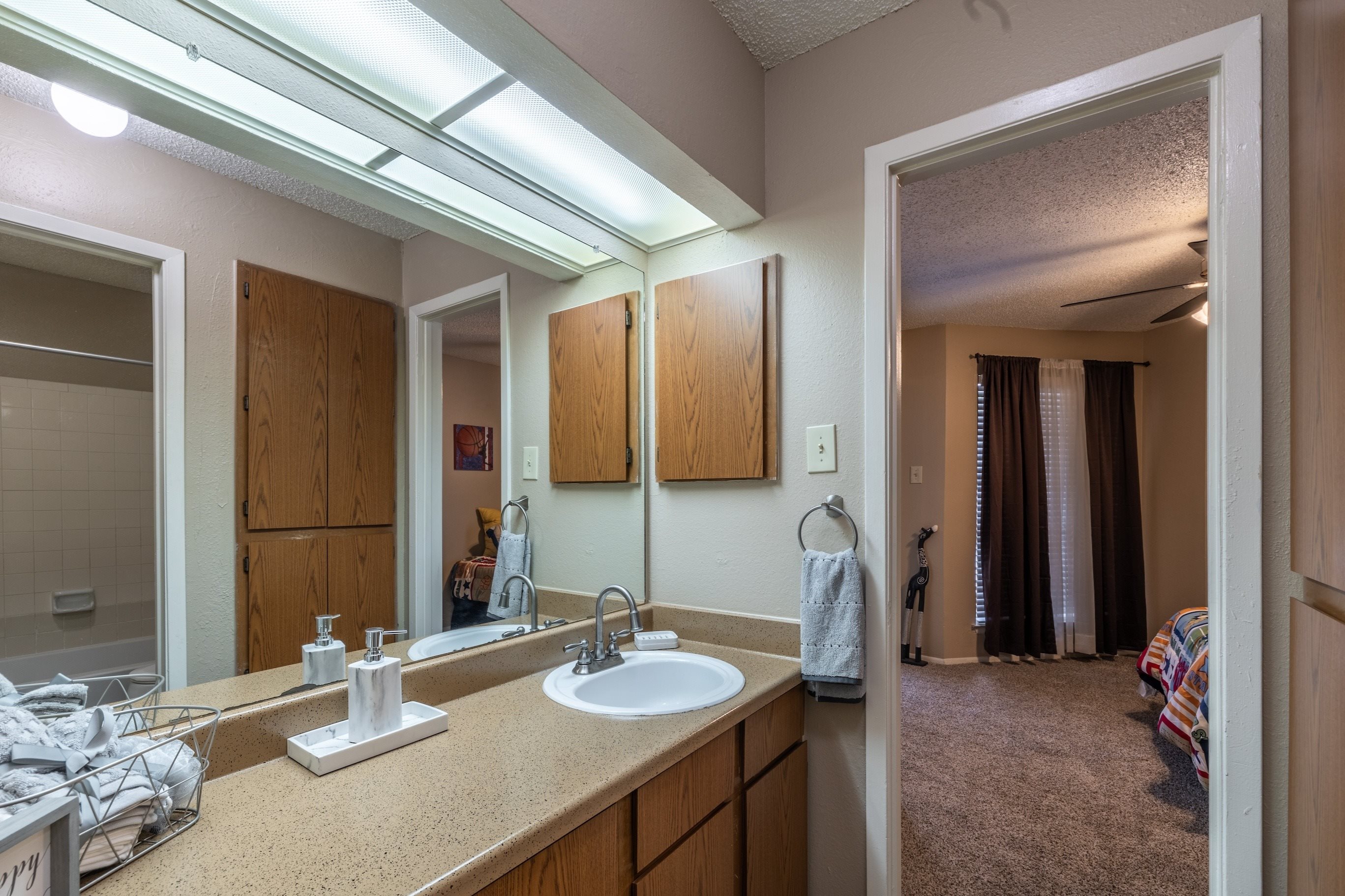 A bathroom with a sink, mirror, and lighting.