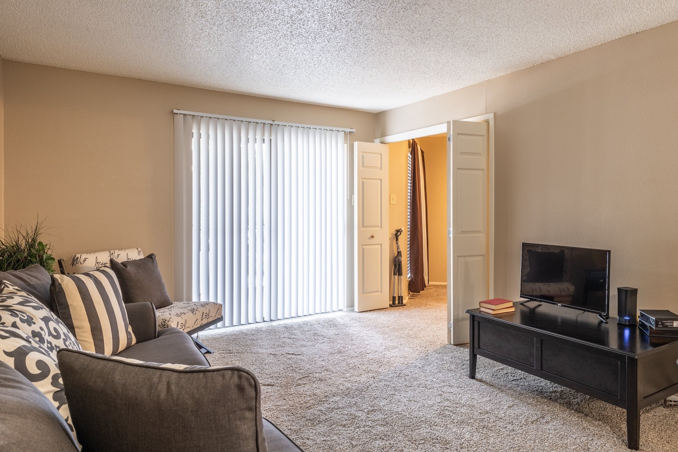 A living room with a grey couch and a black coffee table.