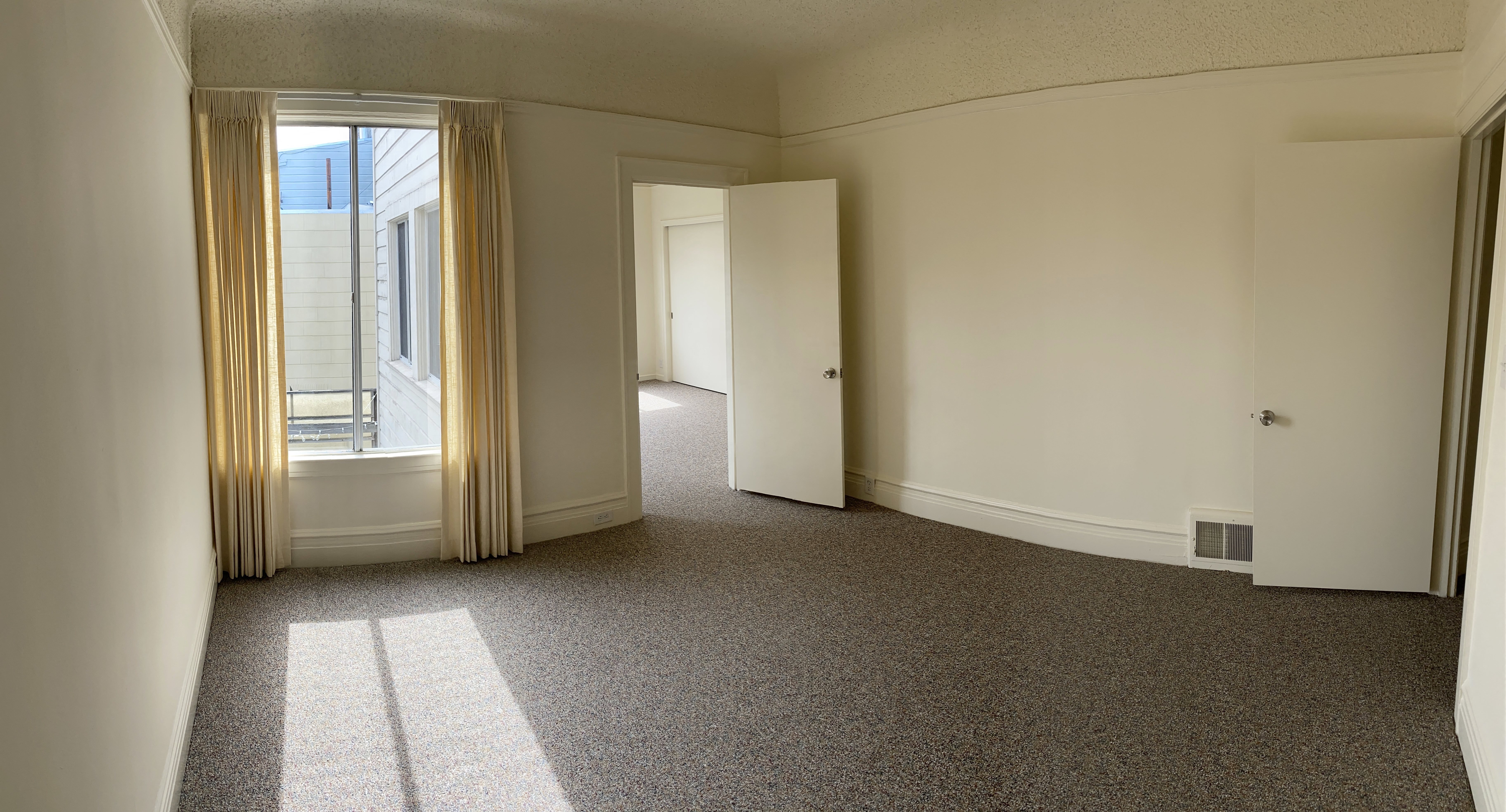 an empty room with a window and a door