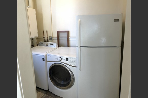 a white washer and dryer in a kitchen next to a refrigerator