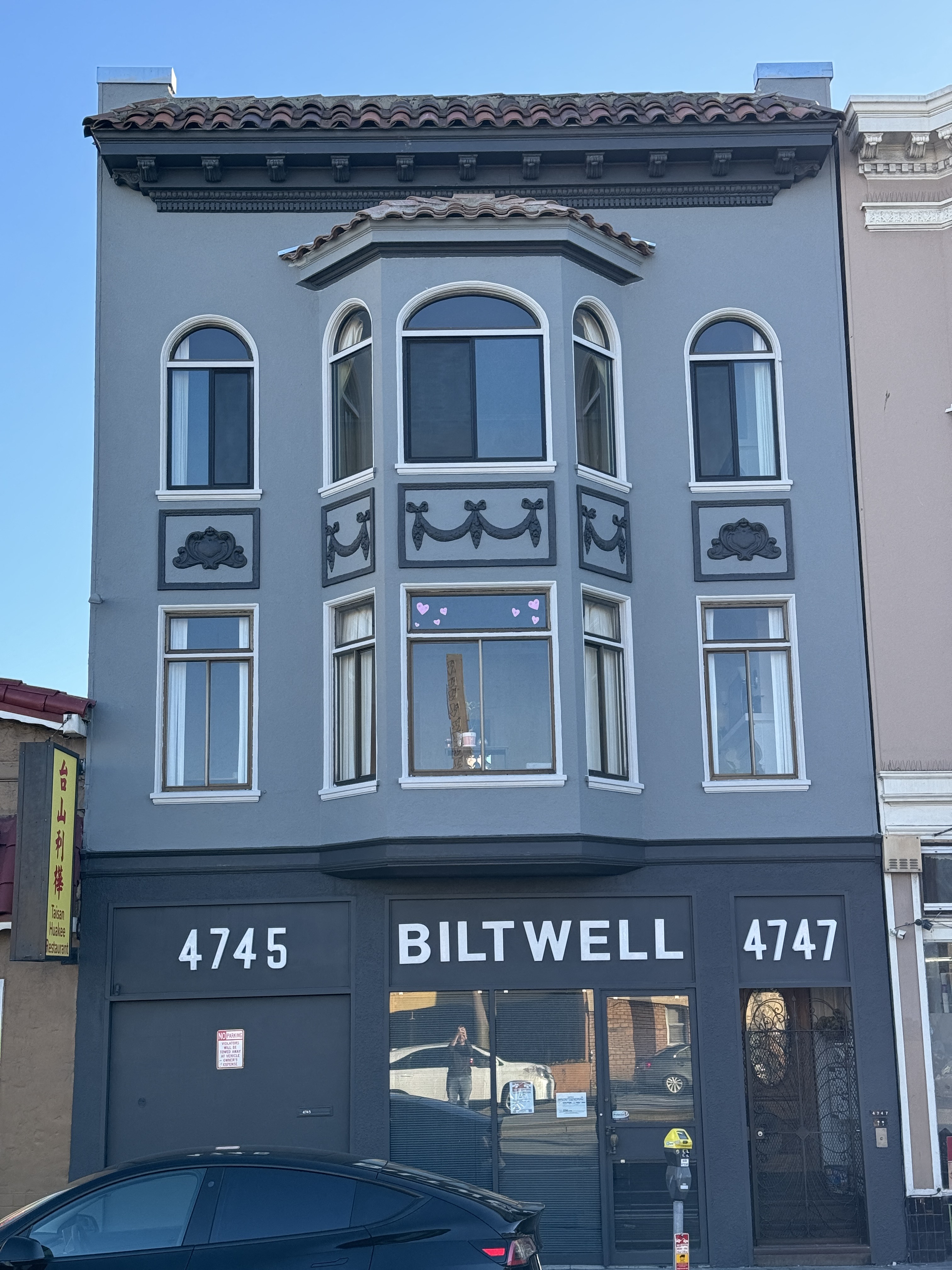 a blue building with a car in front of it