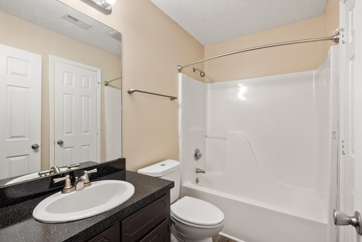 A bathroom with a sink, toilet, and bathtub.