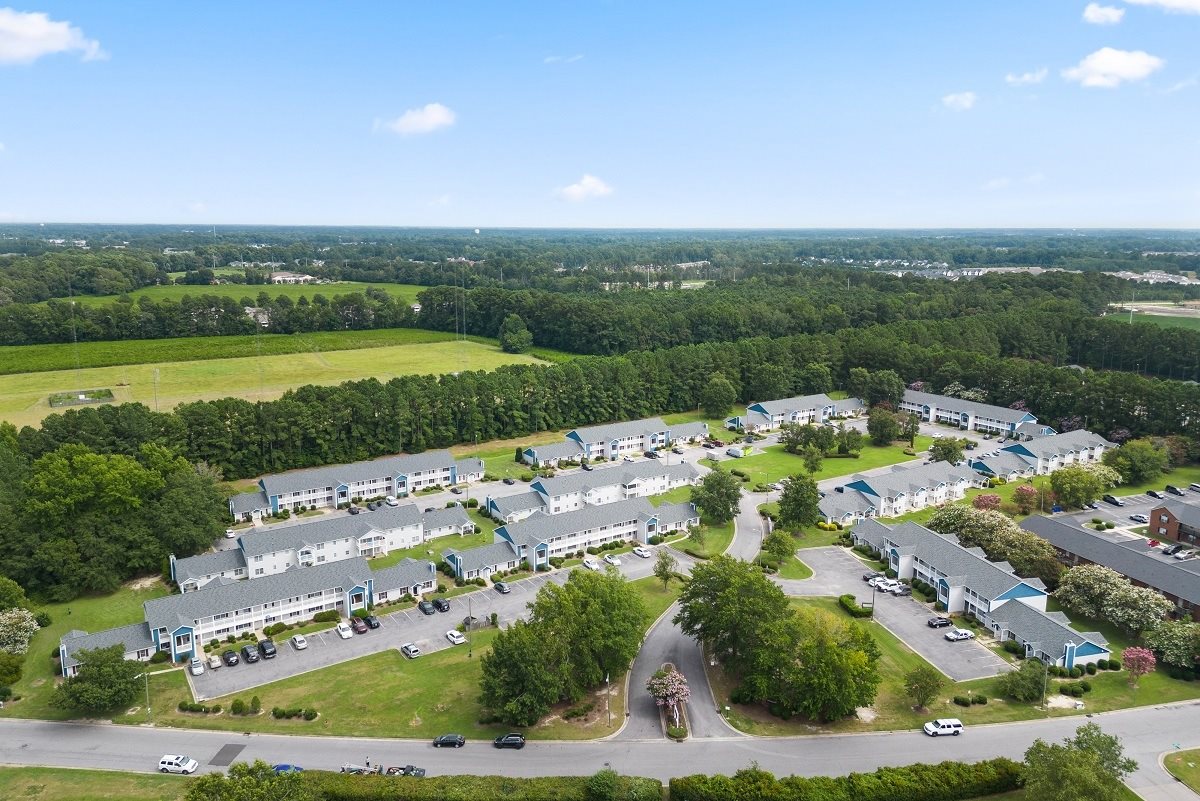 A bird's eye view of a residential complex surrounded by greenery.