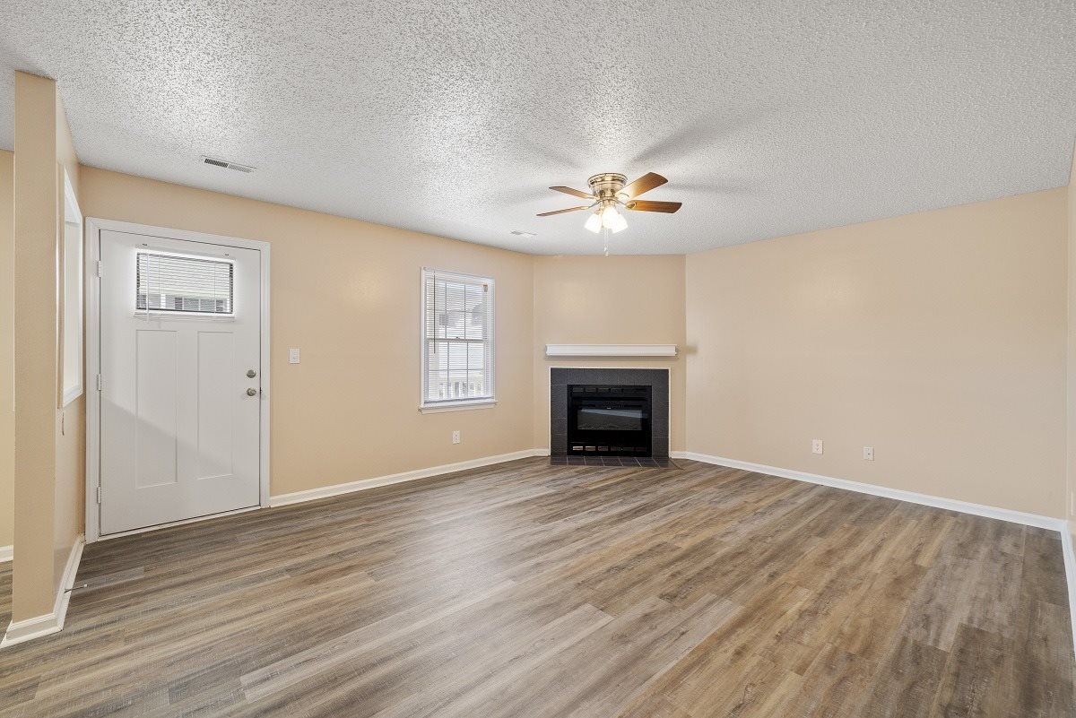 A room with a fireplace and a ceiling fan.