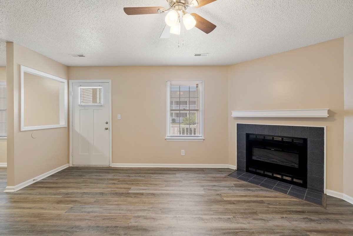 A room with a fireplace and a ceiling fan.