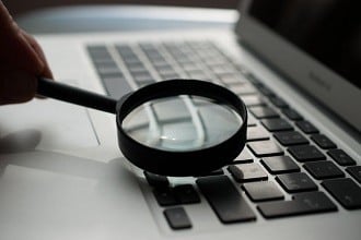 Screening. Magnifying glass over a computer