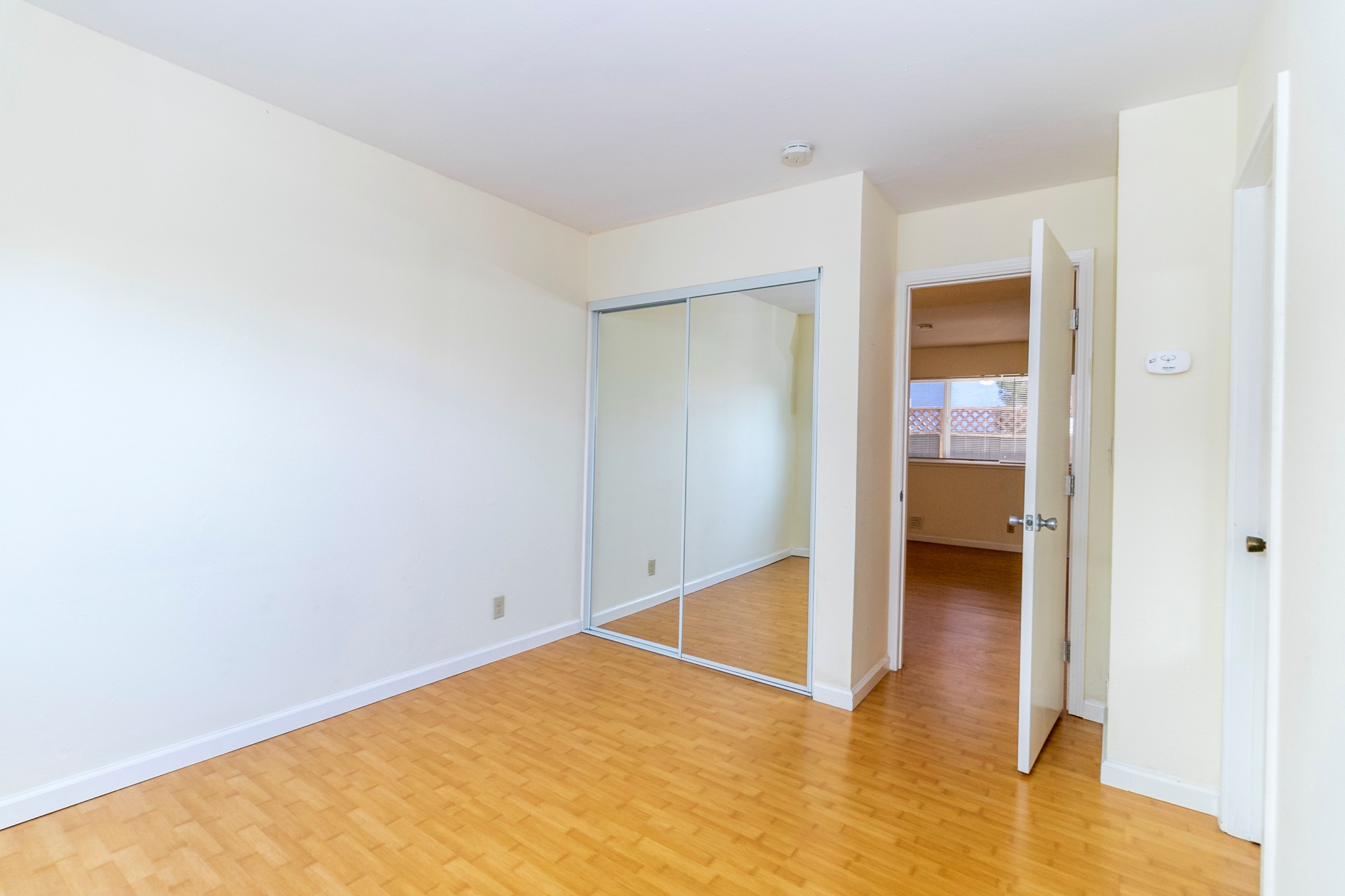 A room with a white wall and a wooden floor.