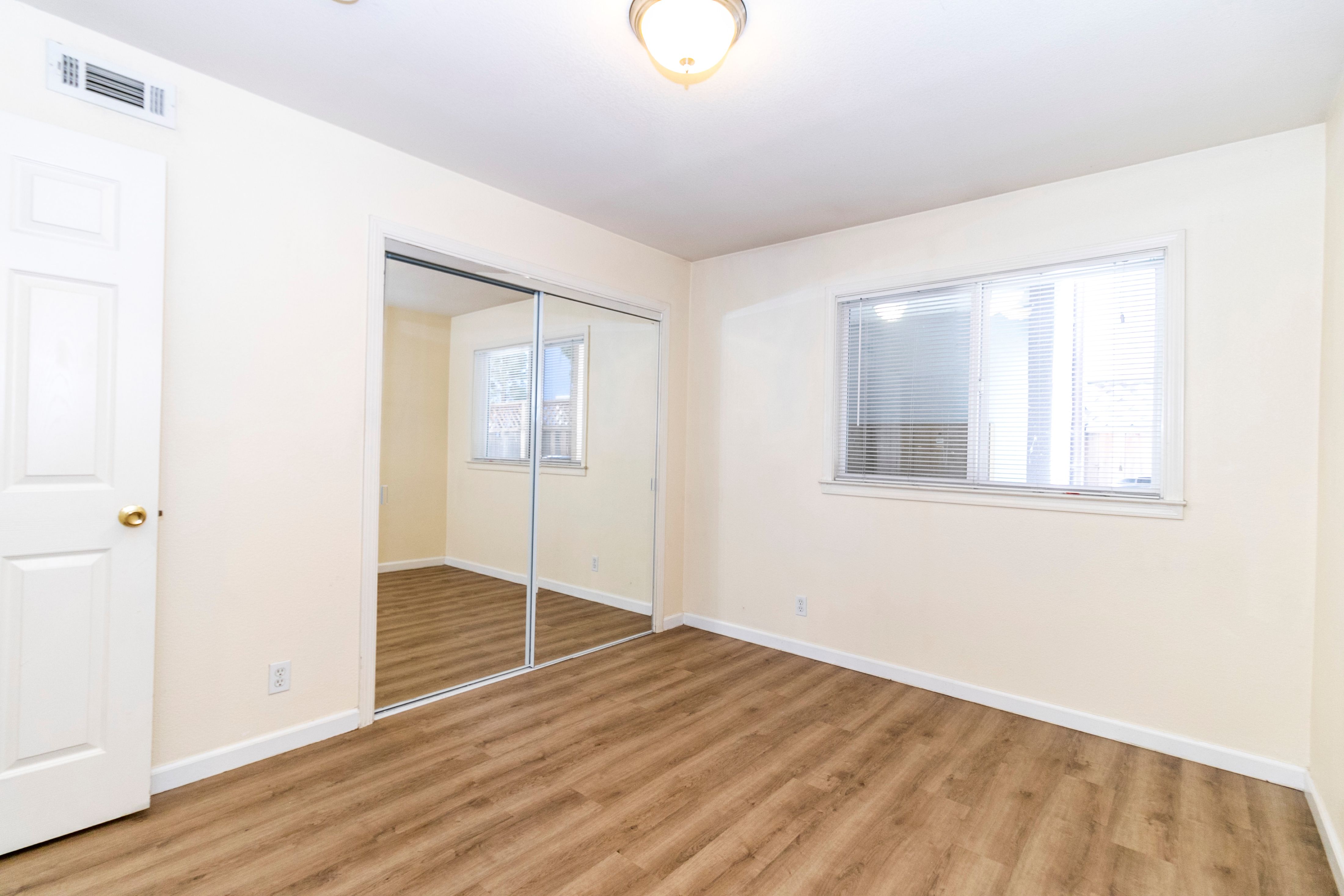 A room with a sliding glass door and a window.