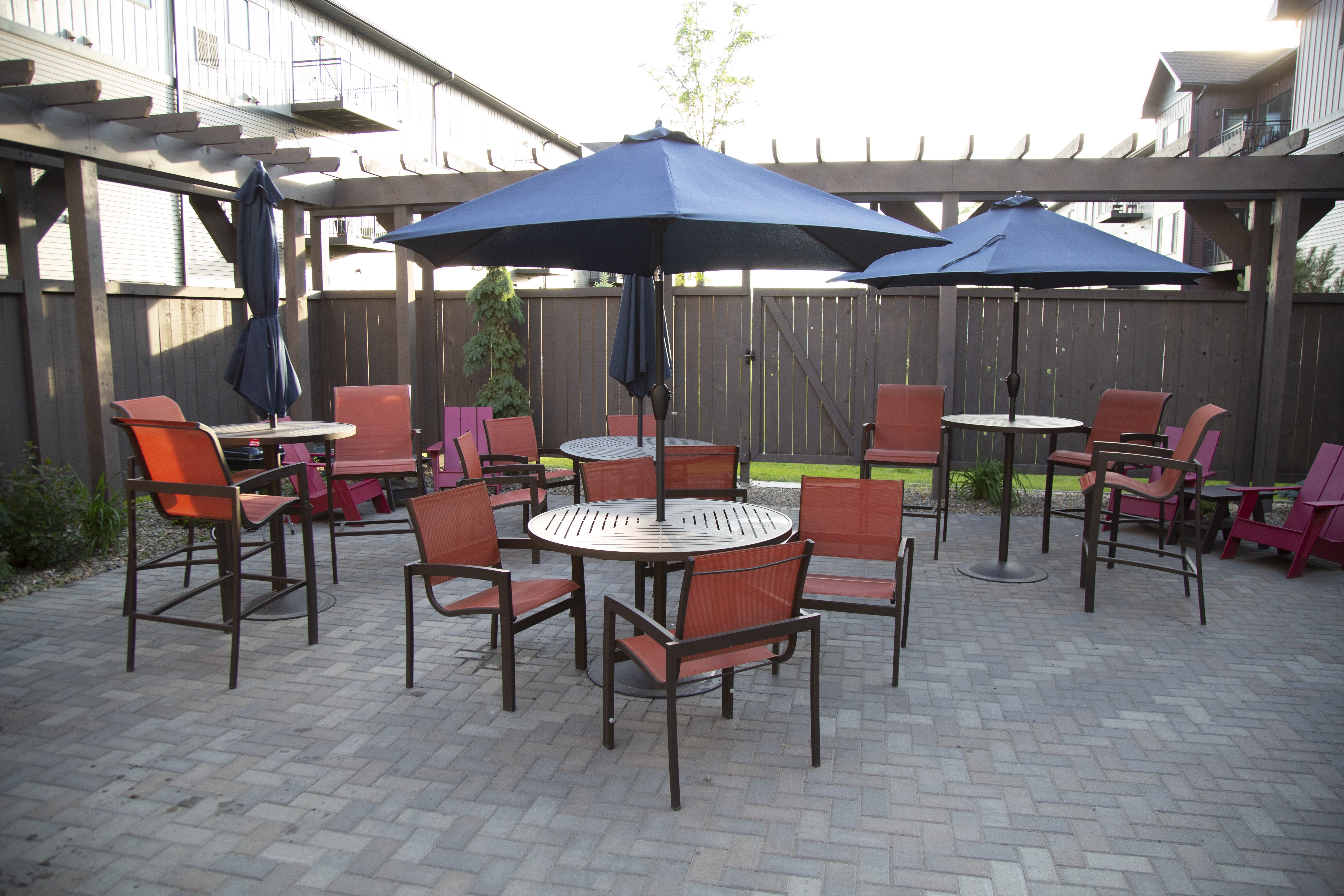 A patio with a table and chairs under a blue umbrella.