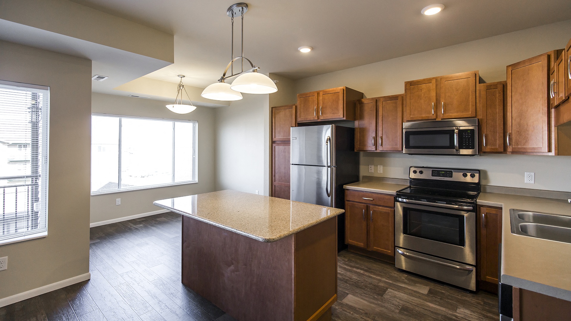 an empty kitchen with wooden cabinets and stainless steel appliances