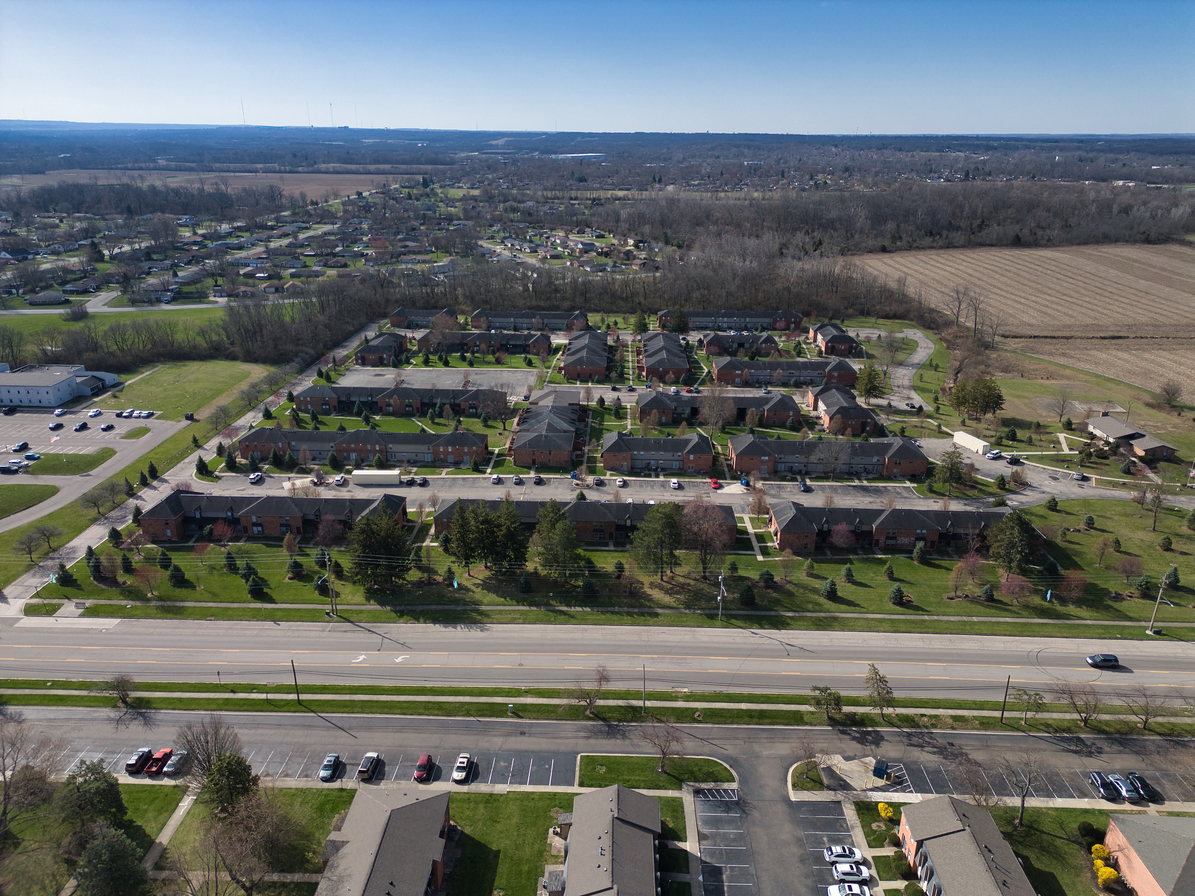 an aerial view of a neighborhood with cars driving on a road and many houses