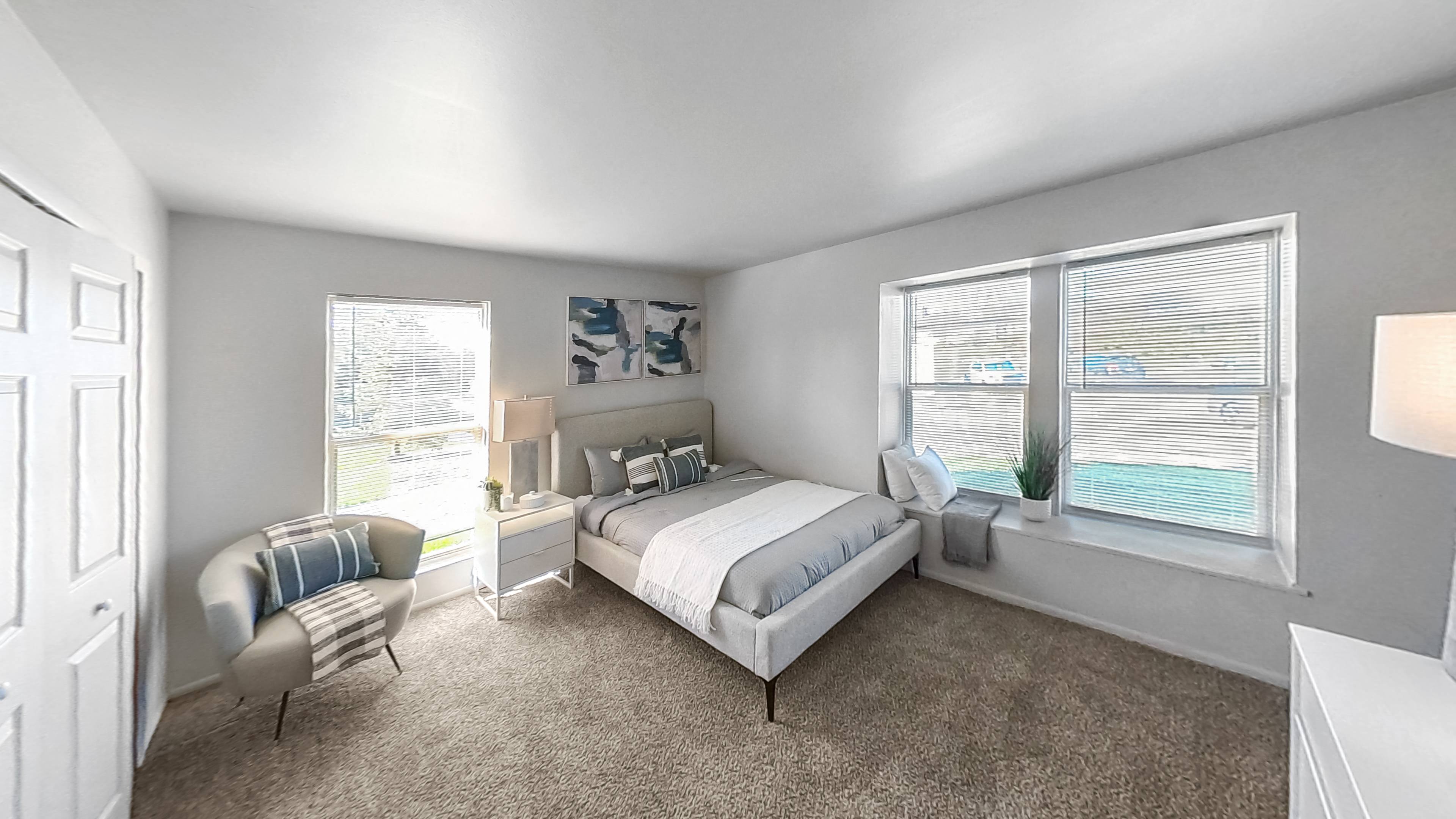 a bedroom with a bed and two windows