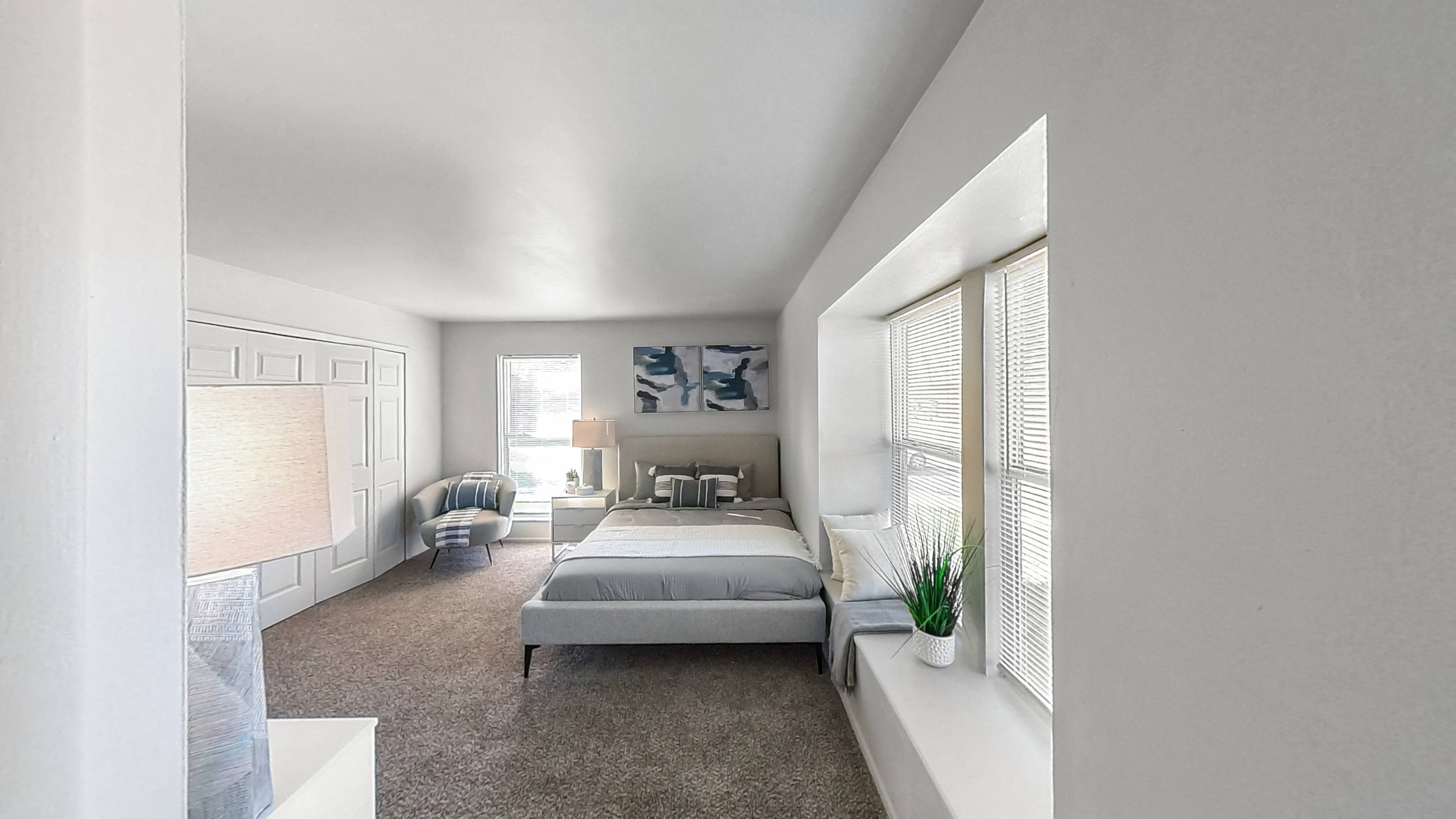 a bedroom with a bed and a large window