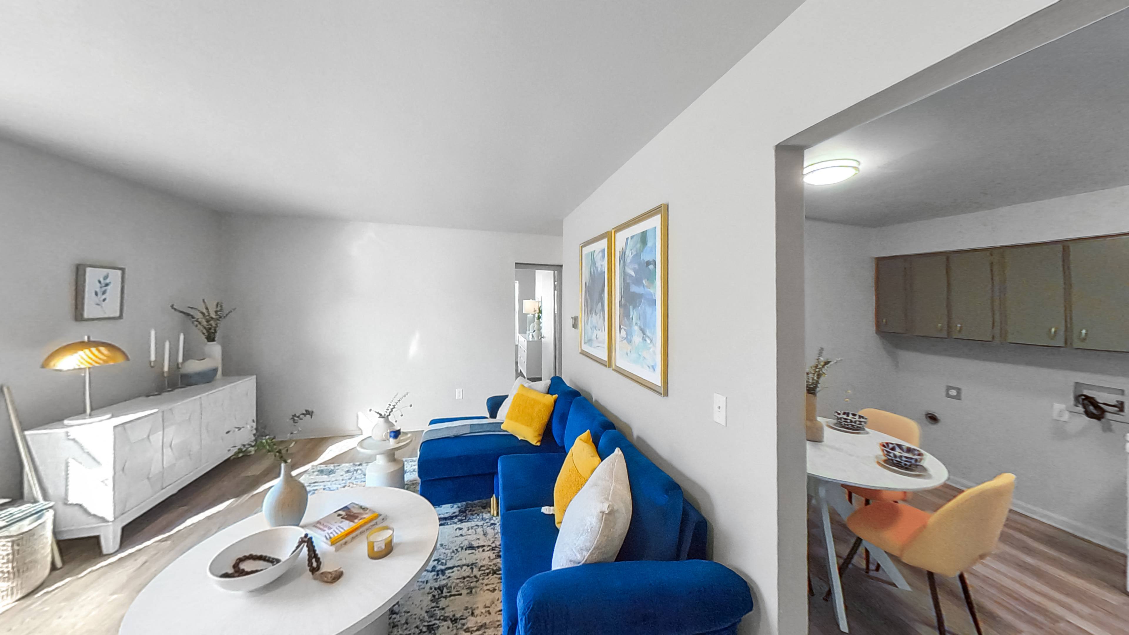 a living room with a blue couch and a white table