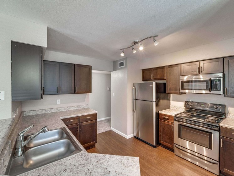 an open kitchen with stainless steel appliances and granite counter tops at Palazzo, San Marcos