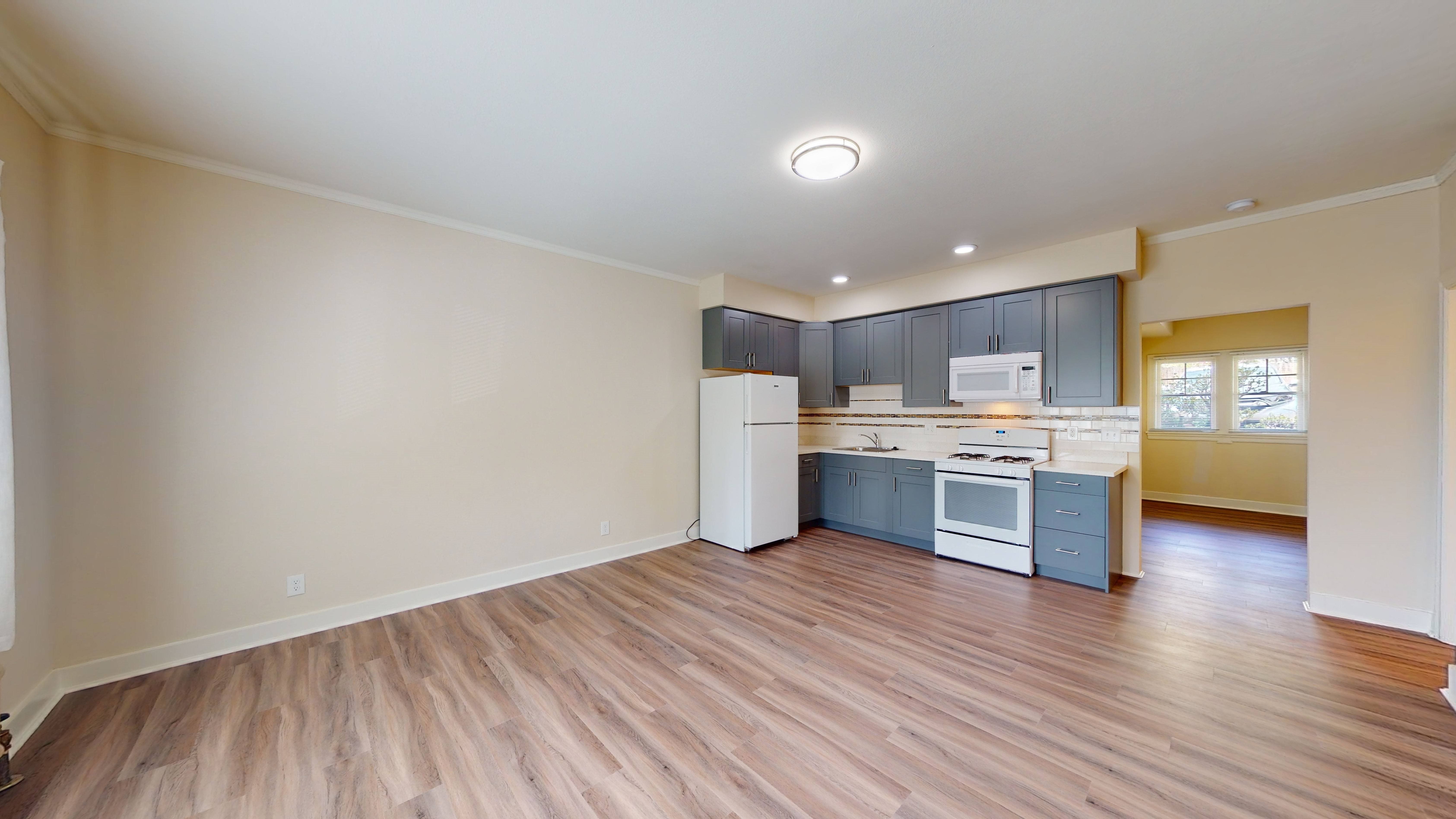 A kitchen with a white refrigerator, white stove, and white oven.